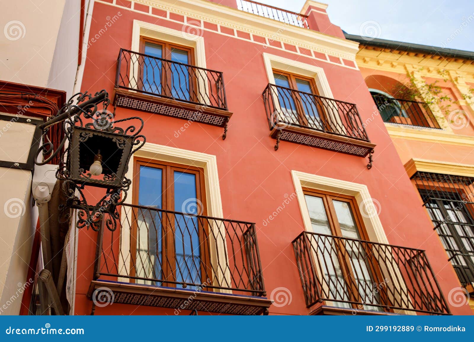 decorative balconies and windows with gates of old city center house in seville, spain