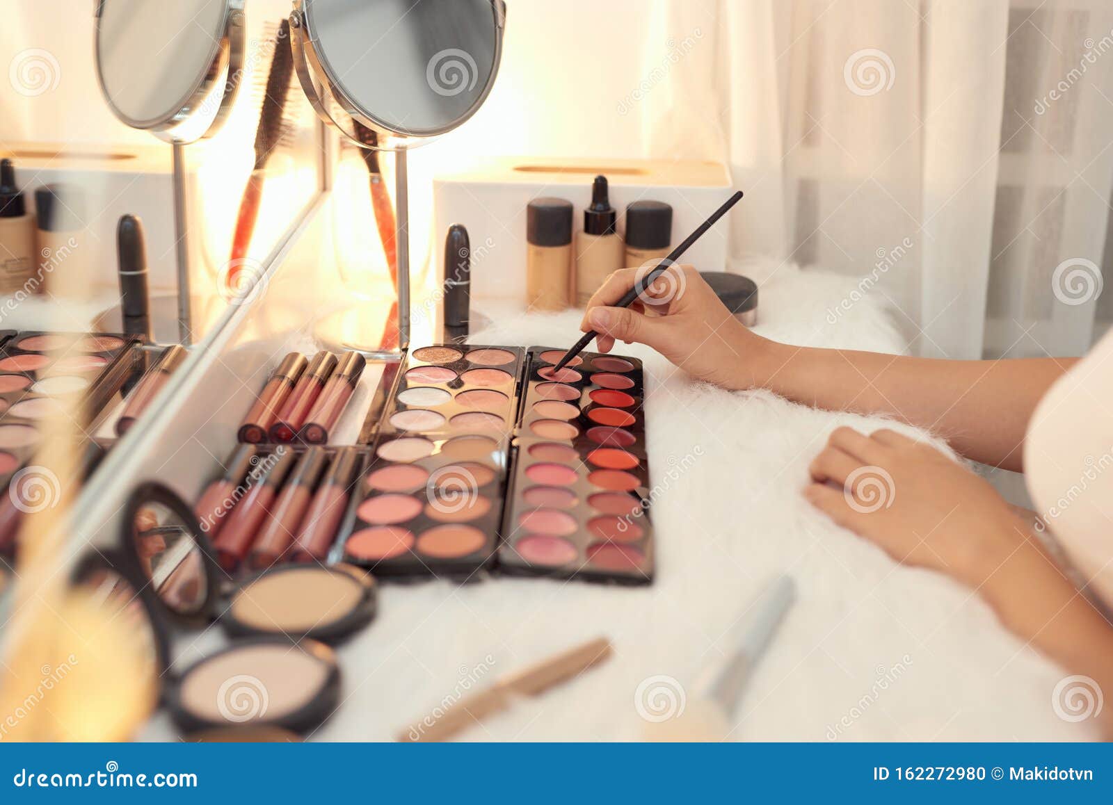 Decorative Cosmetics and Tools on Dressing Table Near Mirror in Makeup