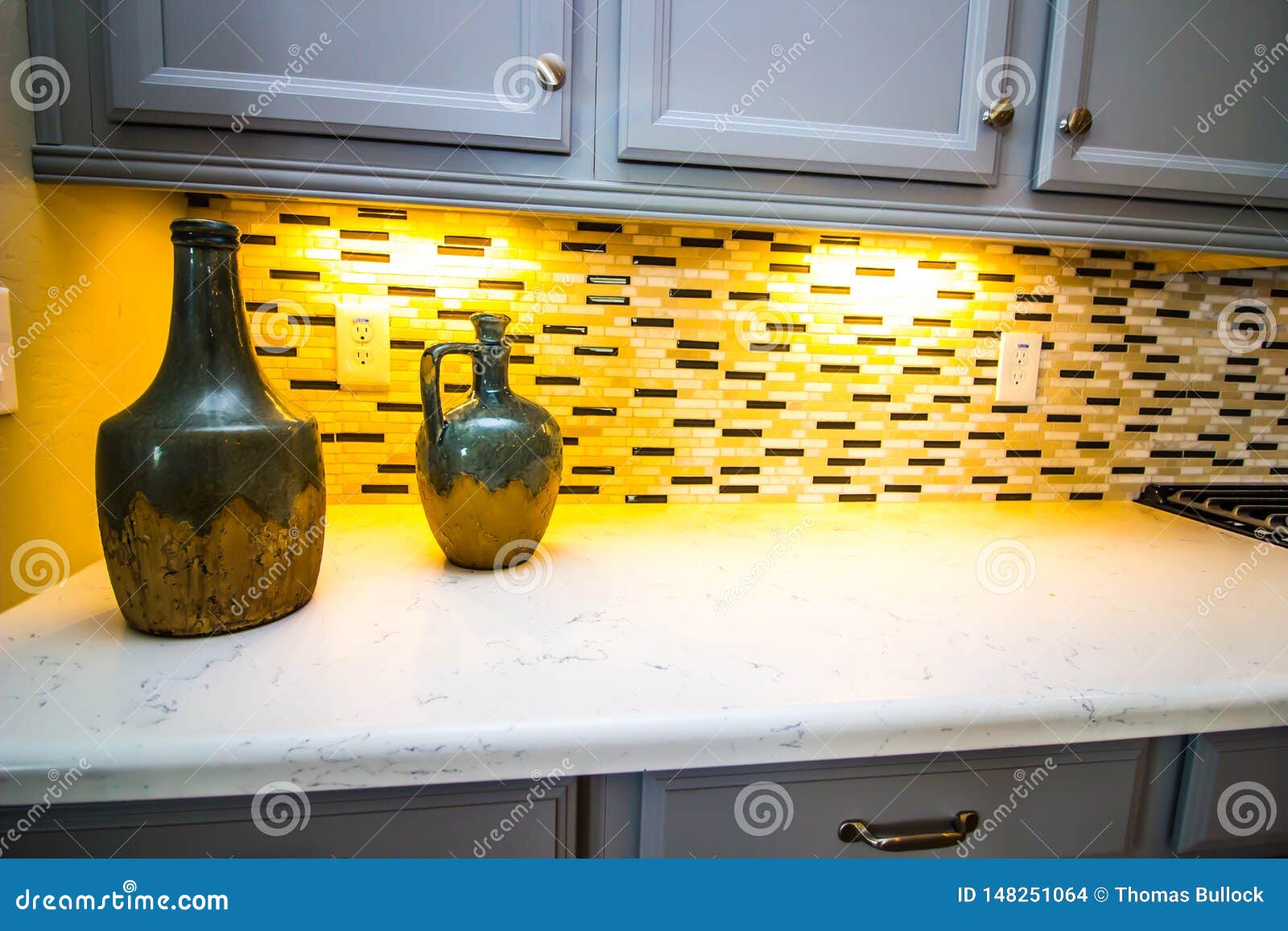 Decorative Jugs on Modern Kitchen Counter with Backsplash Stock Photo