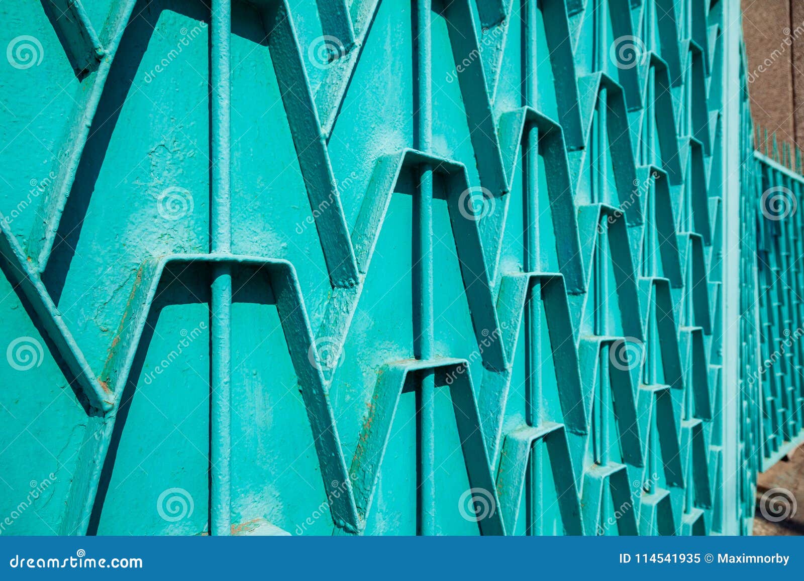 Decorative parts of metal gates. Metal turquois fence. Texture of old metal background. Geometric pattern Concept: creative