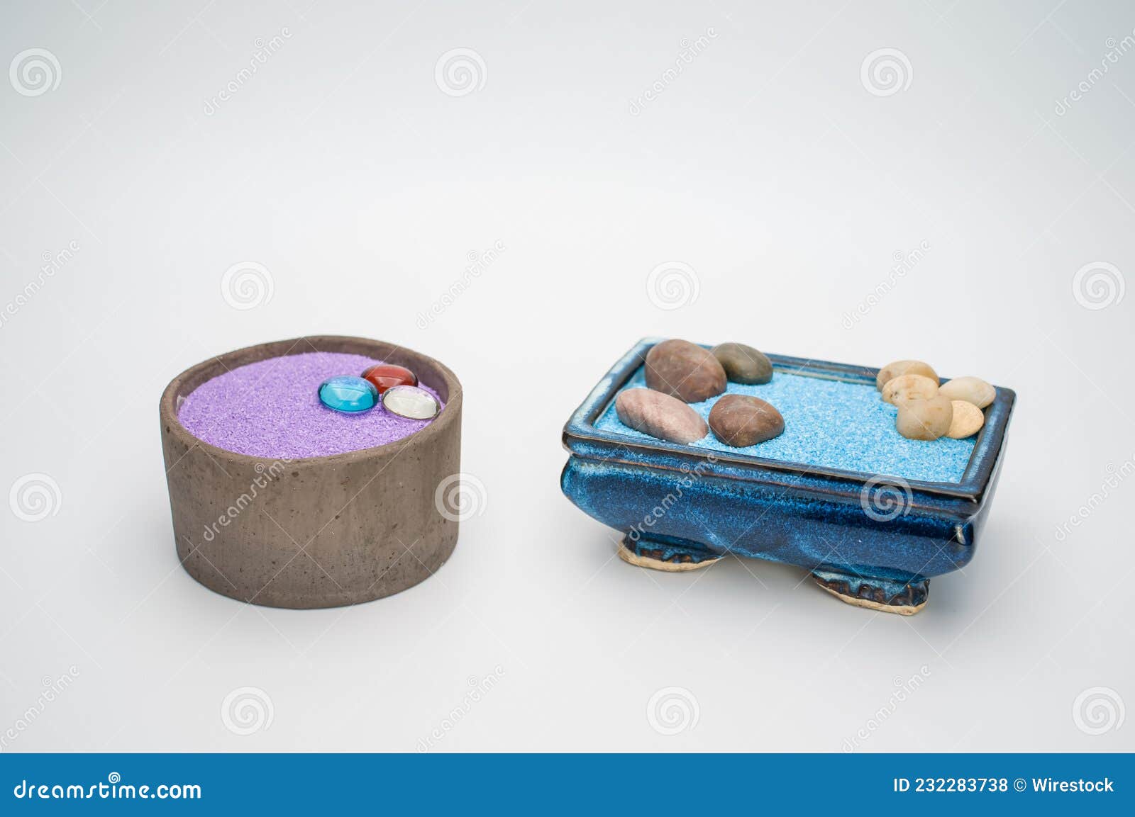 Decorative Vases with Colored Sand and Pebbles on a White Background