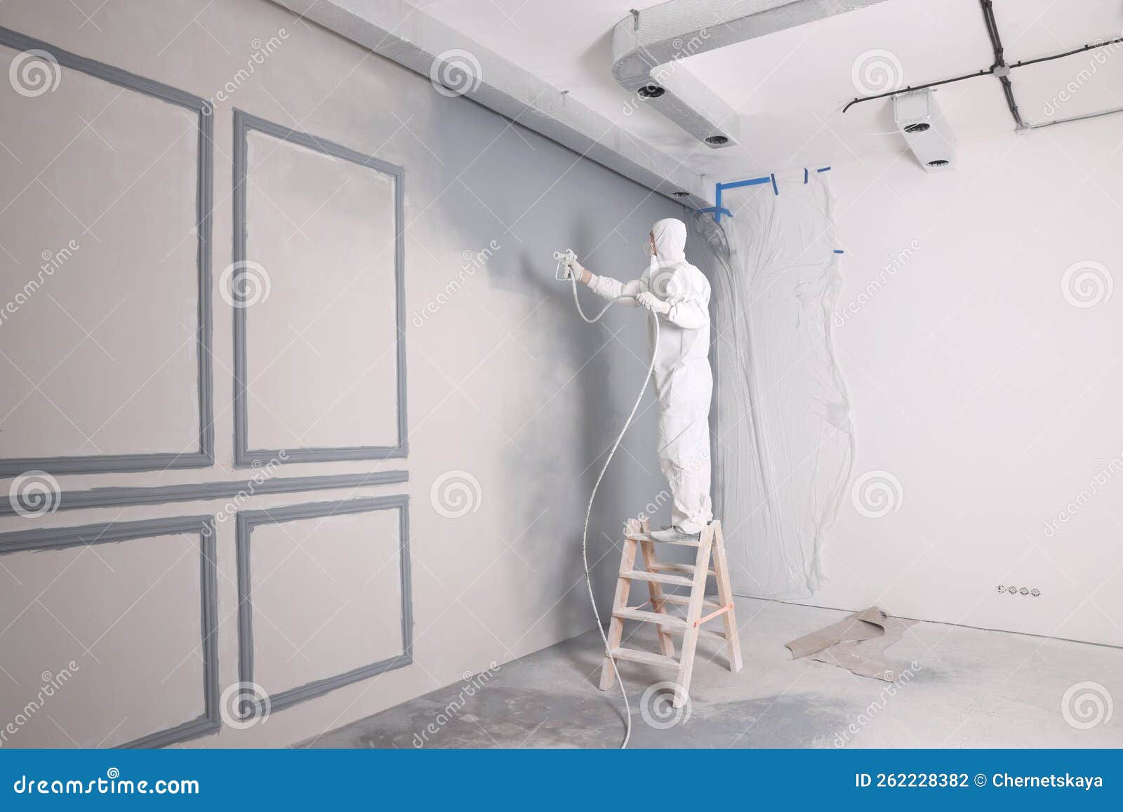 Decorator Dyeing Wall in Grey Color with Spray Paint Indoors Stock
