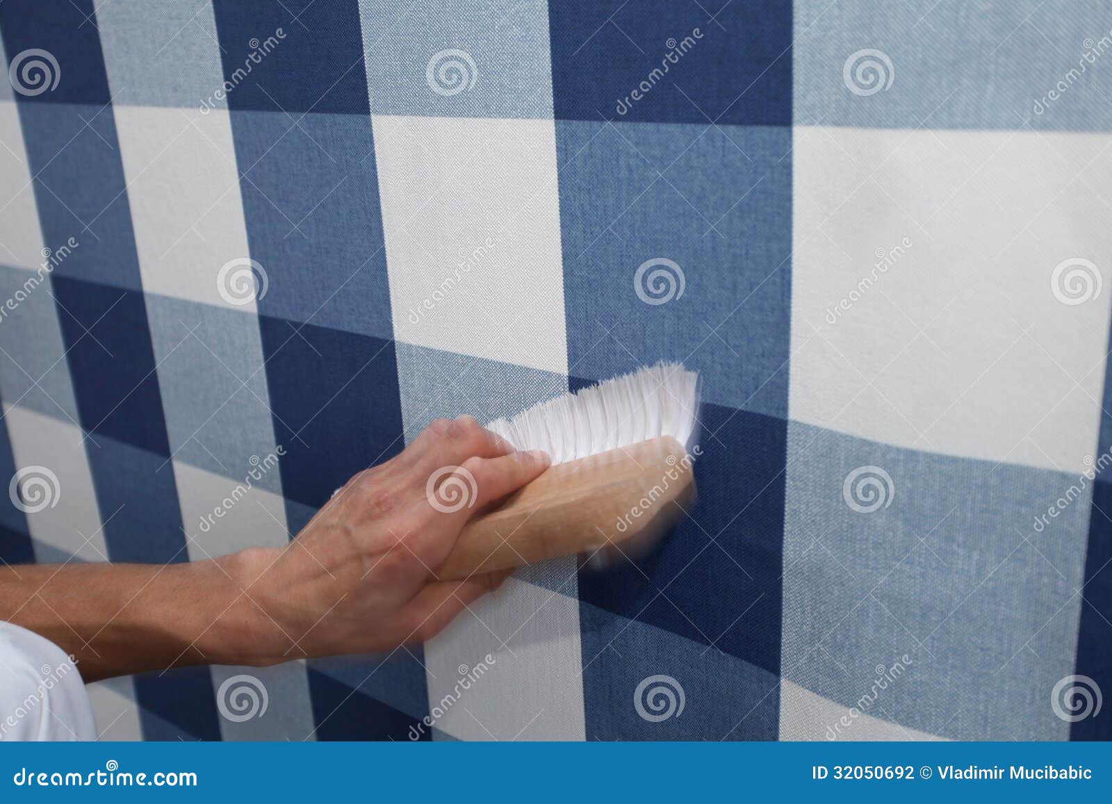 Decorator Hanging Wallpaper with Work Tool in Motion Stock Photo