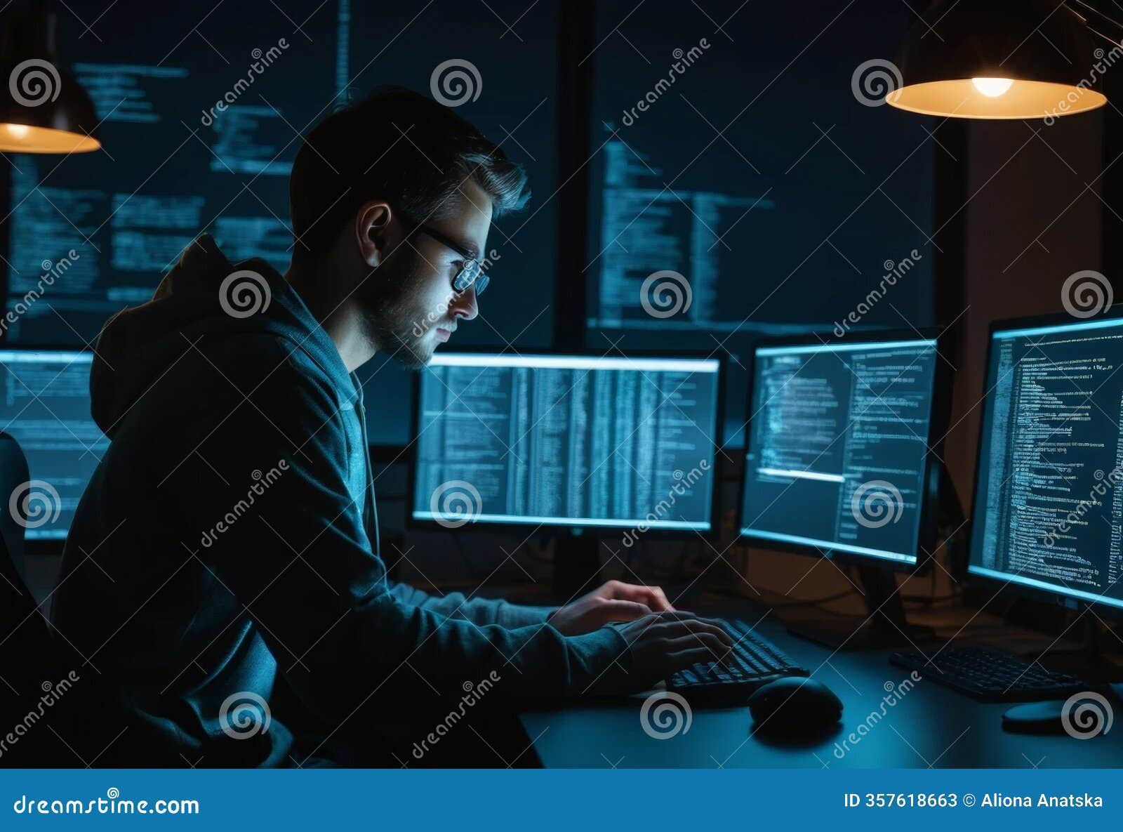 A Dedicated Male Programmer Working Intently at Multiple Monitors ...