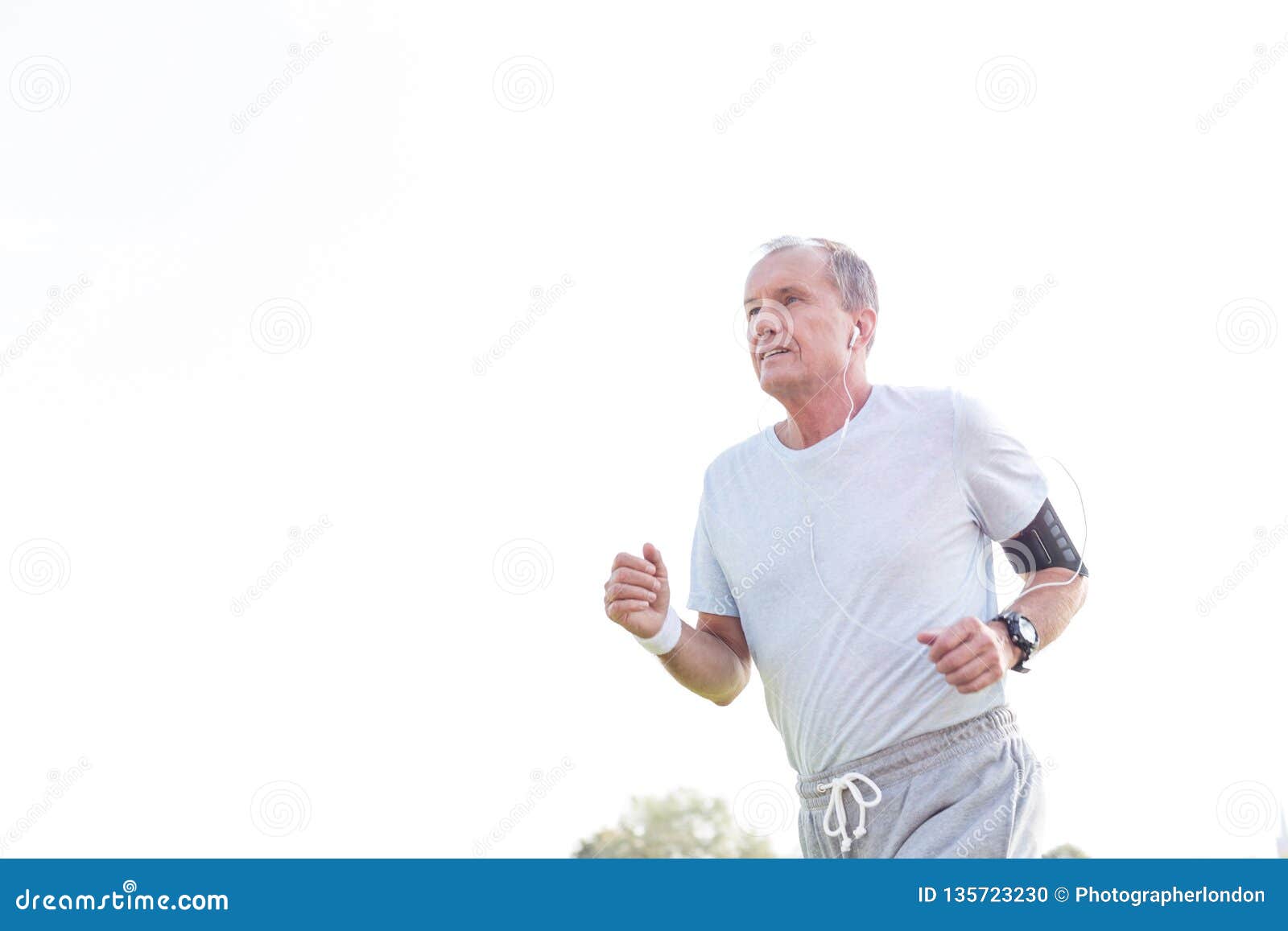 dedicated senior man jogging against sky