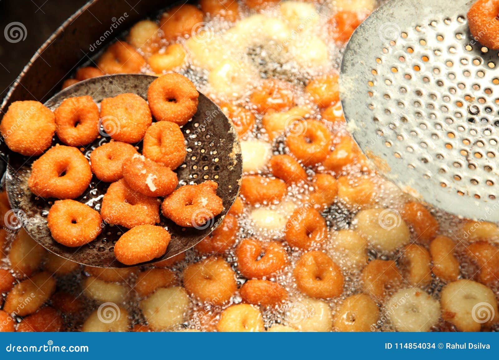deep frying medu vada in the pan. medu vada is a savoury snack from south india, very common street food