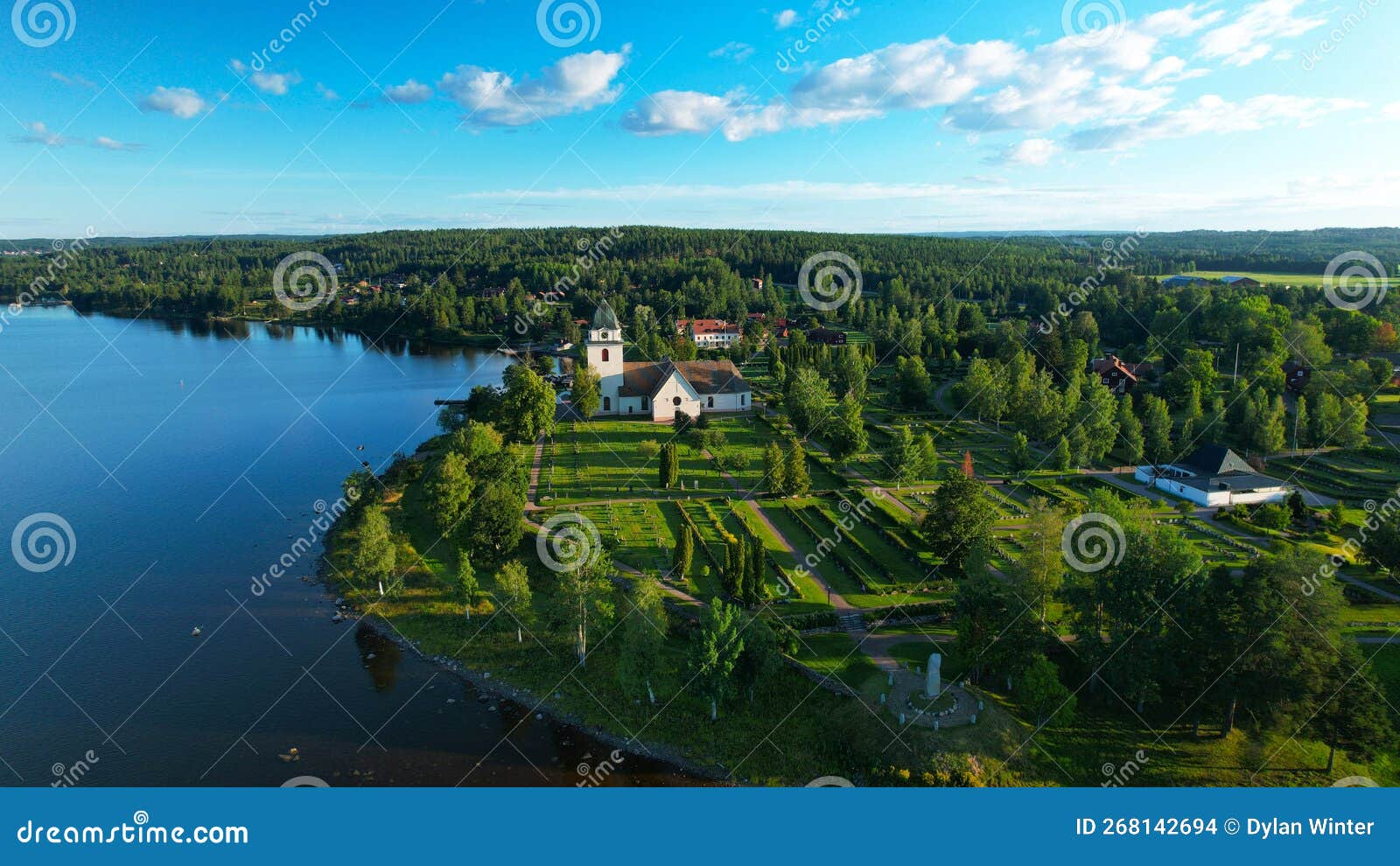 aerial view of a church and cemetery by the lakeside of siljan lake rattvik