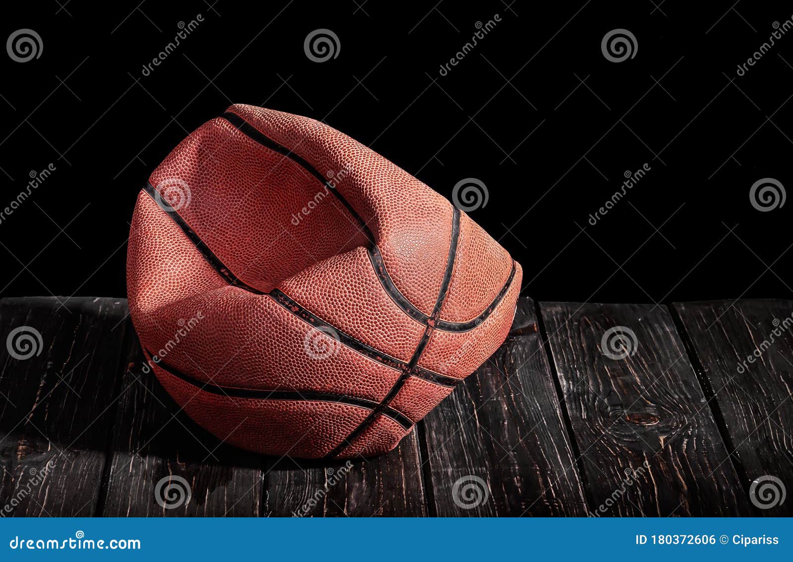 deflated and rumpled old ball on a wooden floor