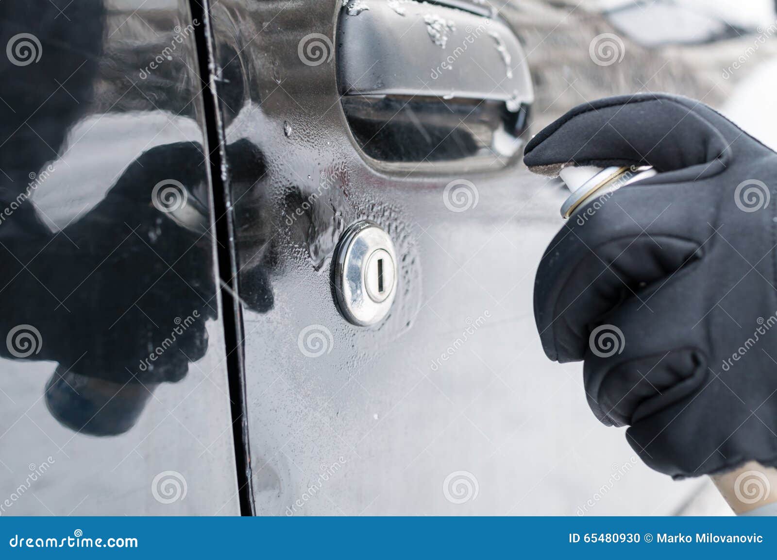 Closeup Of A Woman Using A Defrost Spray On Her Car Window Stock