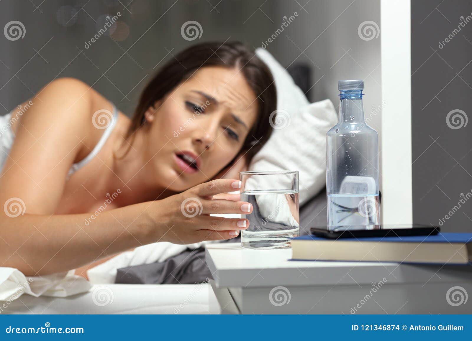 dehydrated woman reaching a glass of water