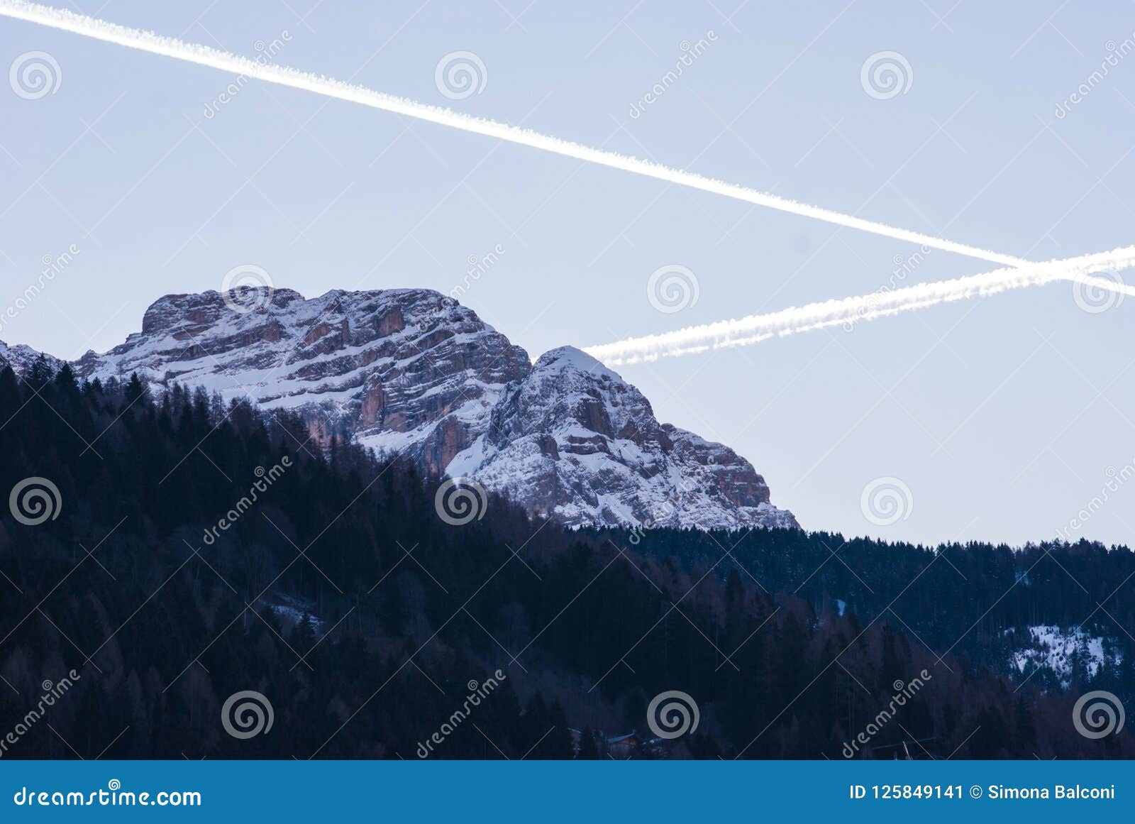 Del av Dolomites med snö på skymningen i Trentino Alto Ad. Sikt av Dolomitesbergen med ett kors av upplysta vaker som lämnas från nivå två
