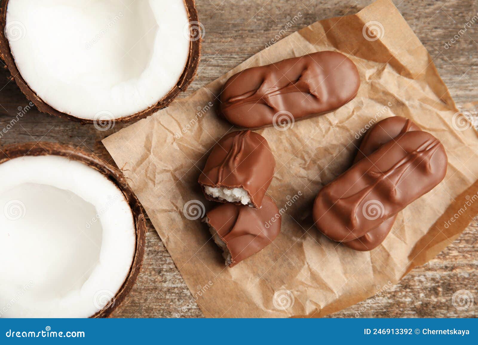 Deliciosos Doces De Chocolate De Leite Com Recheio De Coco Sobre Mesa De Madeira Foto de Stock