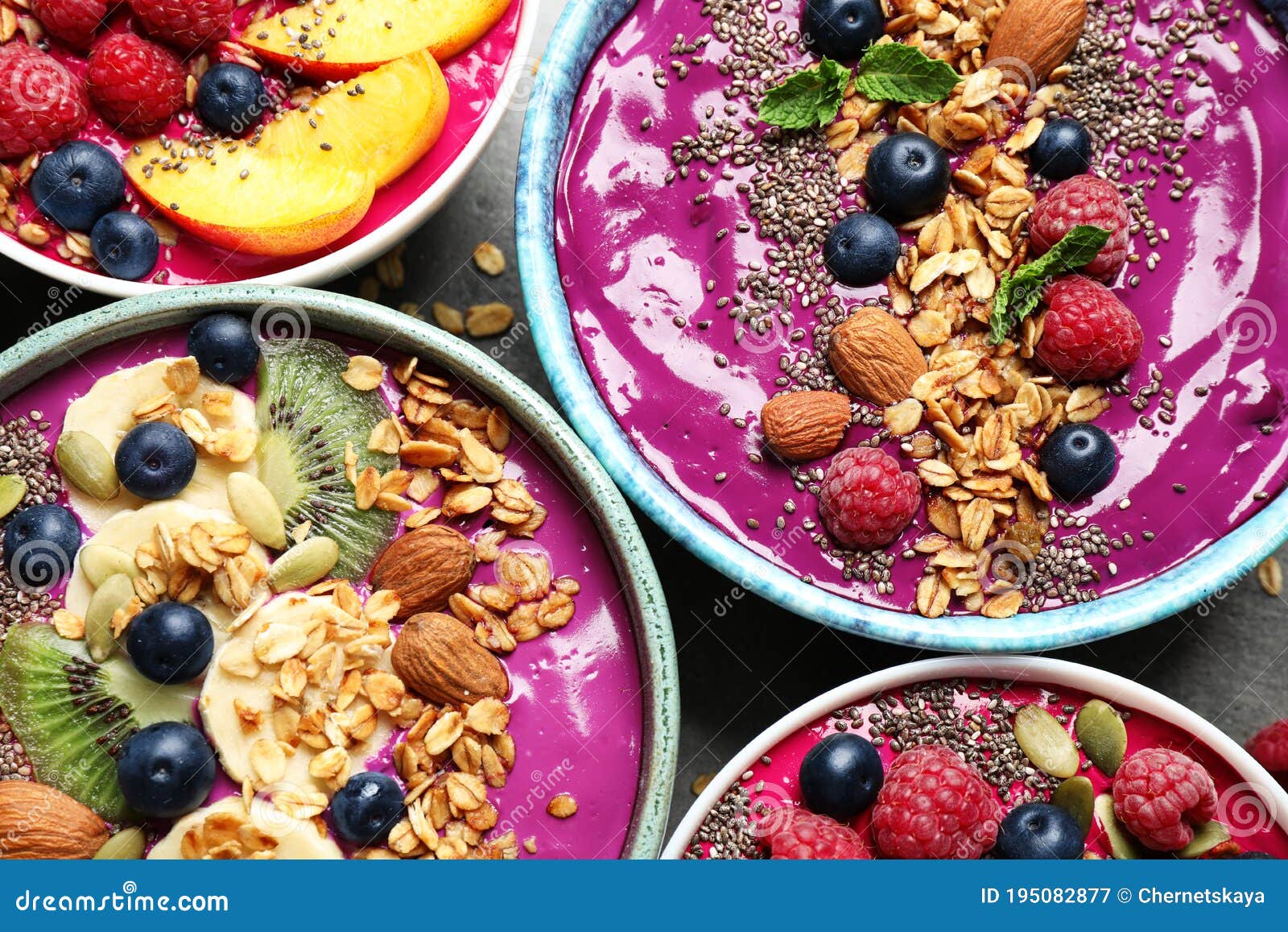 delicious acai smoothie with toppings in bowls on table