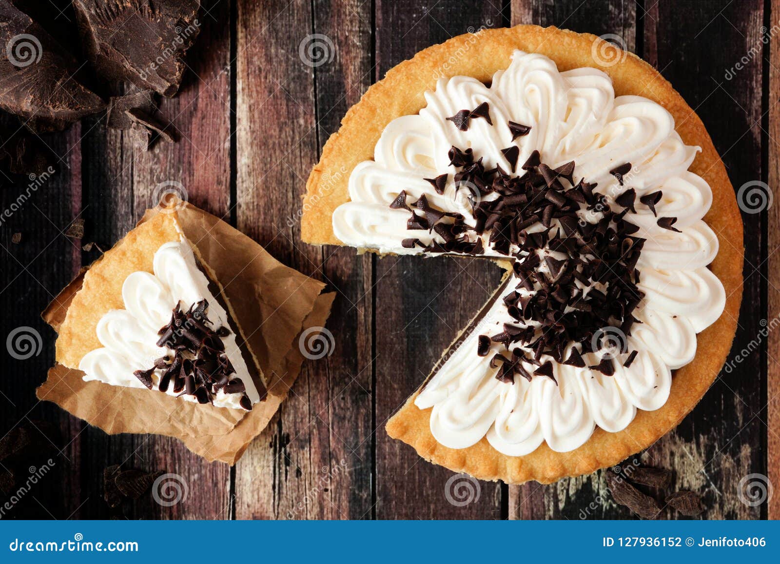 chocolate cream pie, top view scene with slice removed on dark wood