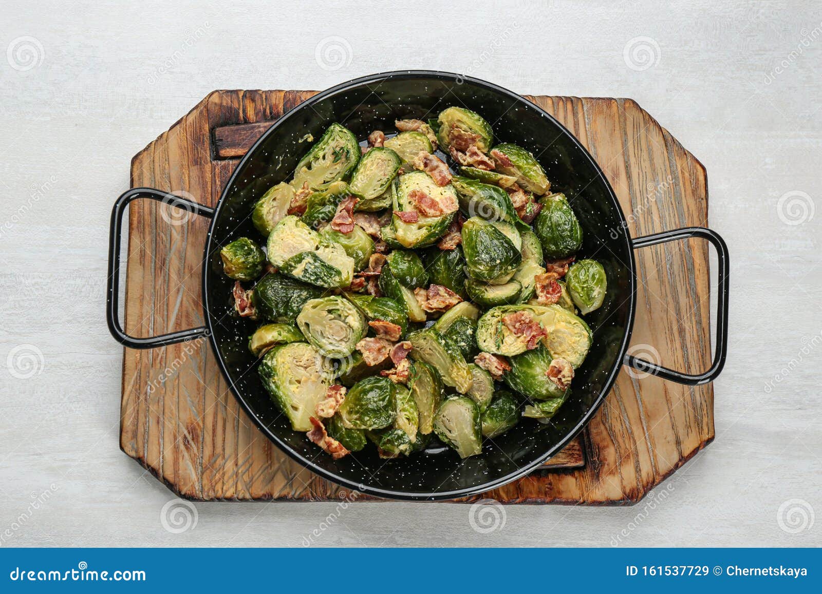 Delicious Cooked Brussels Sprouts with Bacon in Pan on White Table