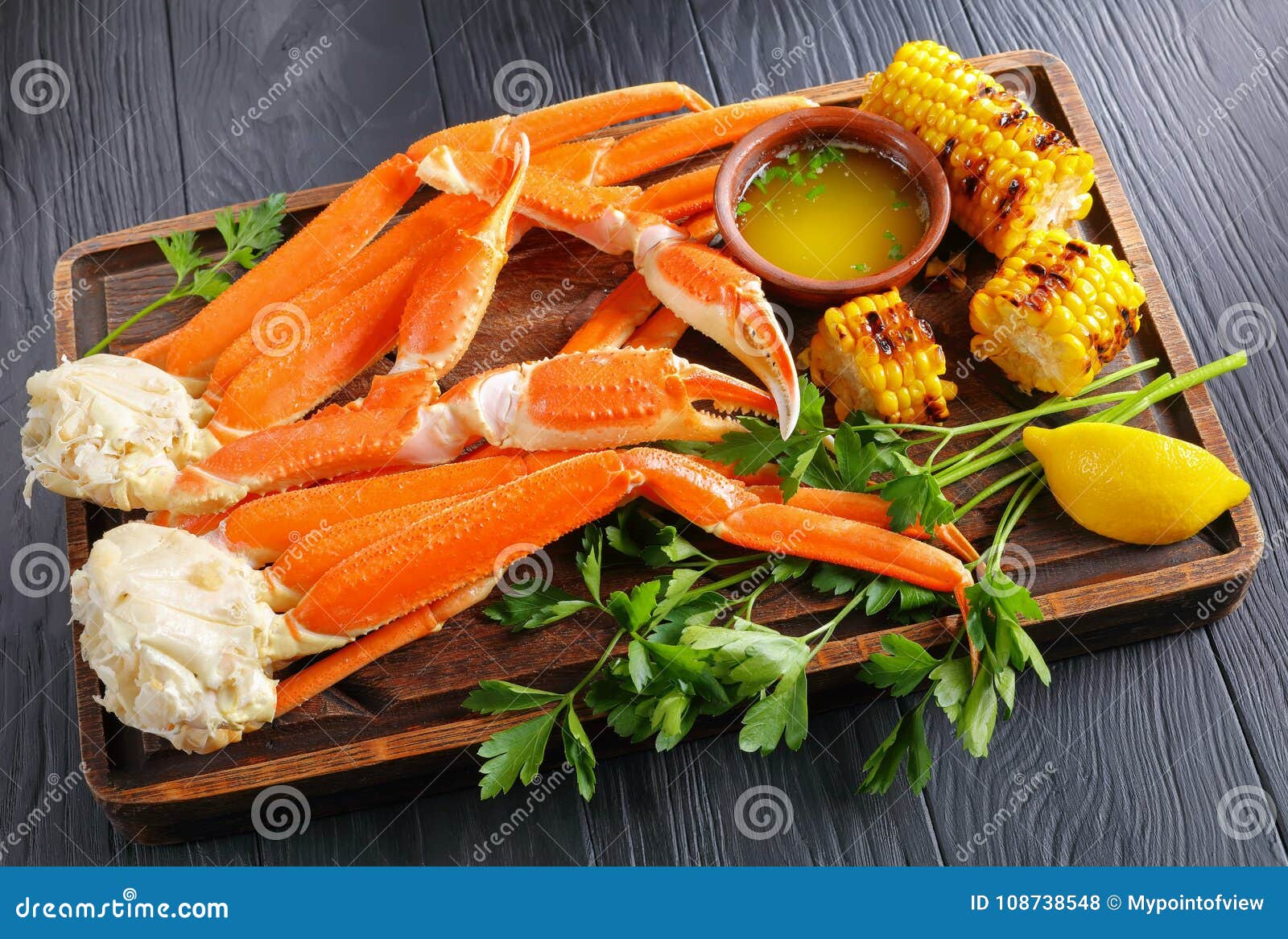 snow crab legs served with corn cobs