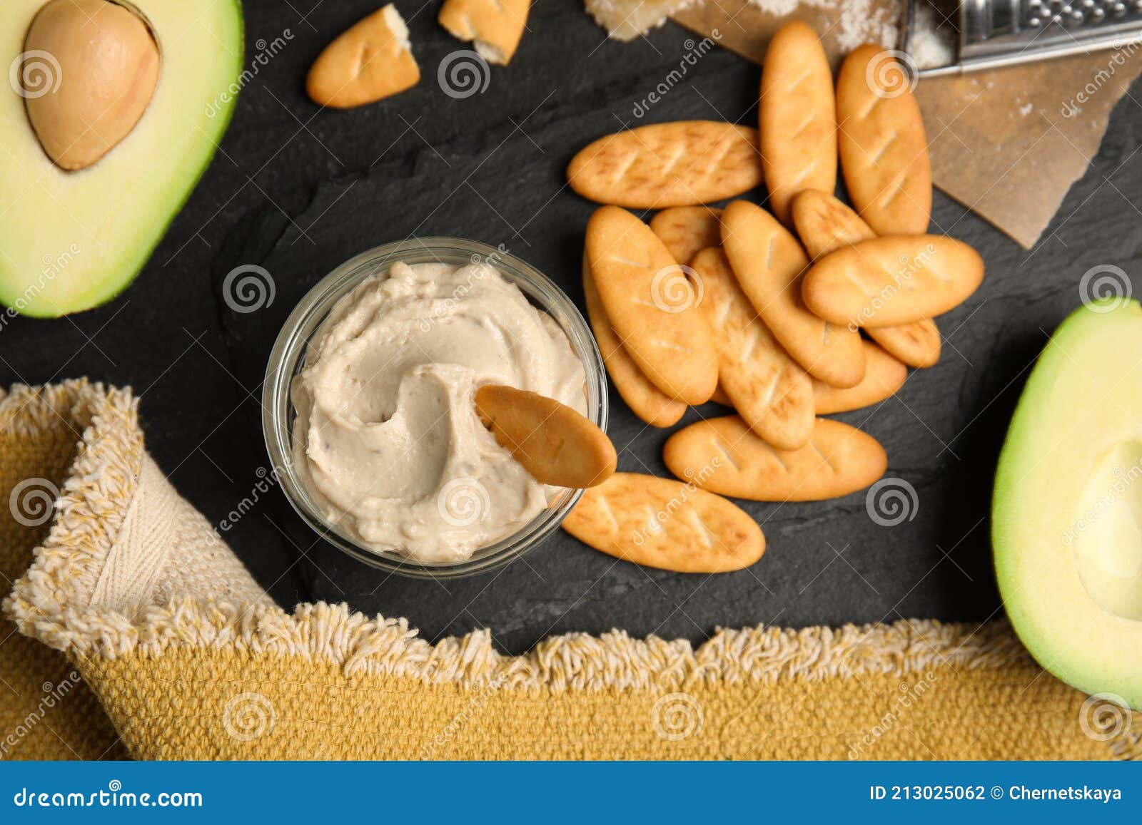 Delicious Crackers and Humus on Black Table, Flat Lay Stock Photo