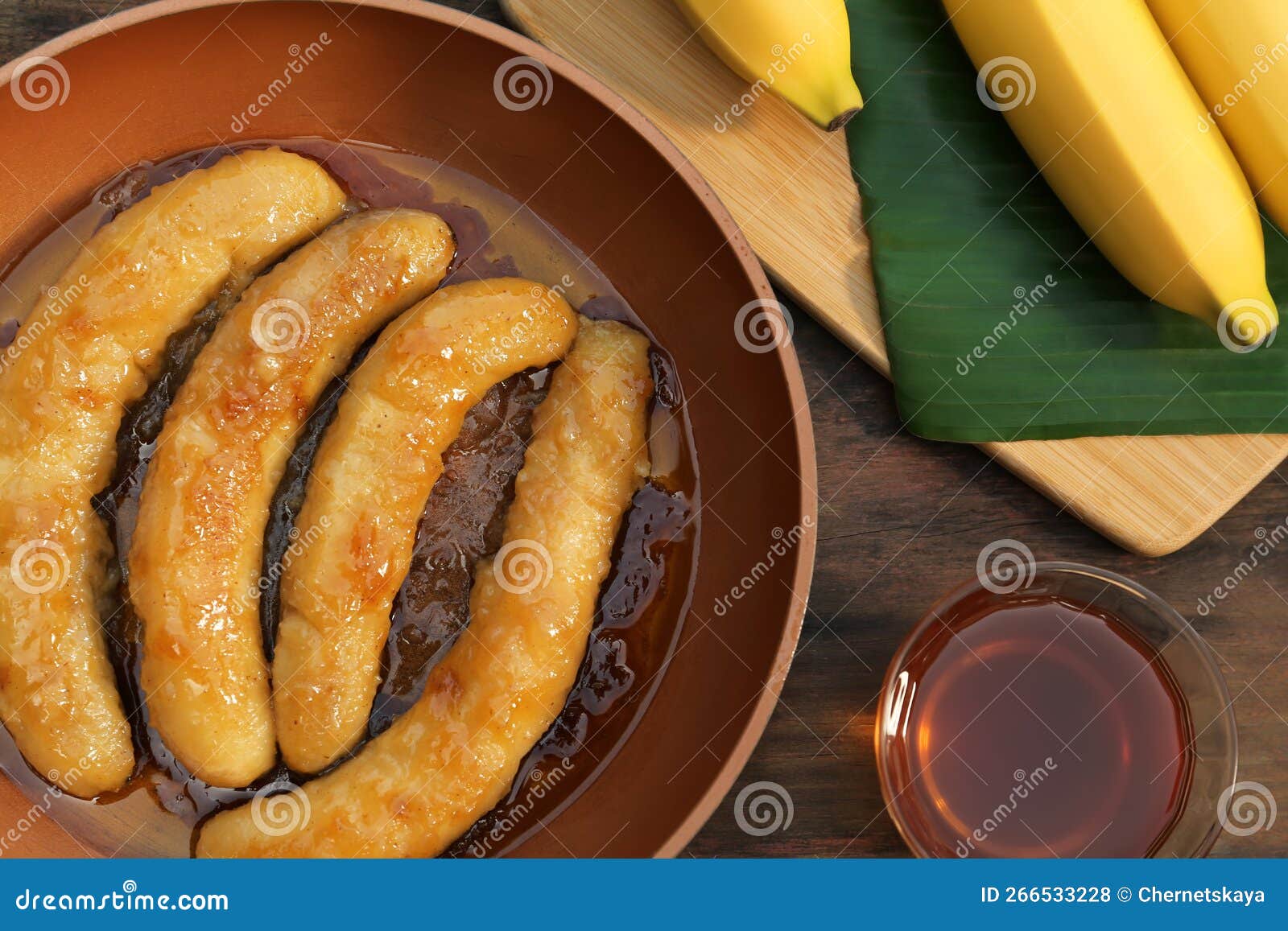 Delicious Fresh and Fried Bananas with Rum on Wooden Table, Flat Lay