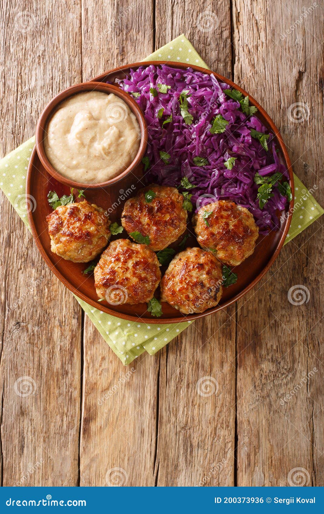 delicious meatballs served with stewed red cabbage garnish and sauce close-up on the table. vertical top view