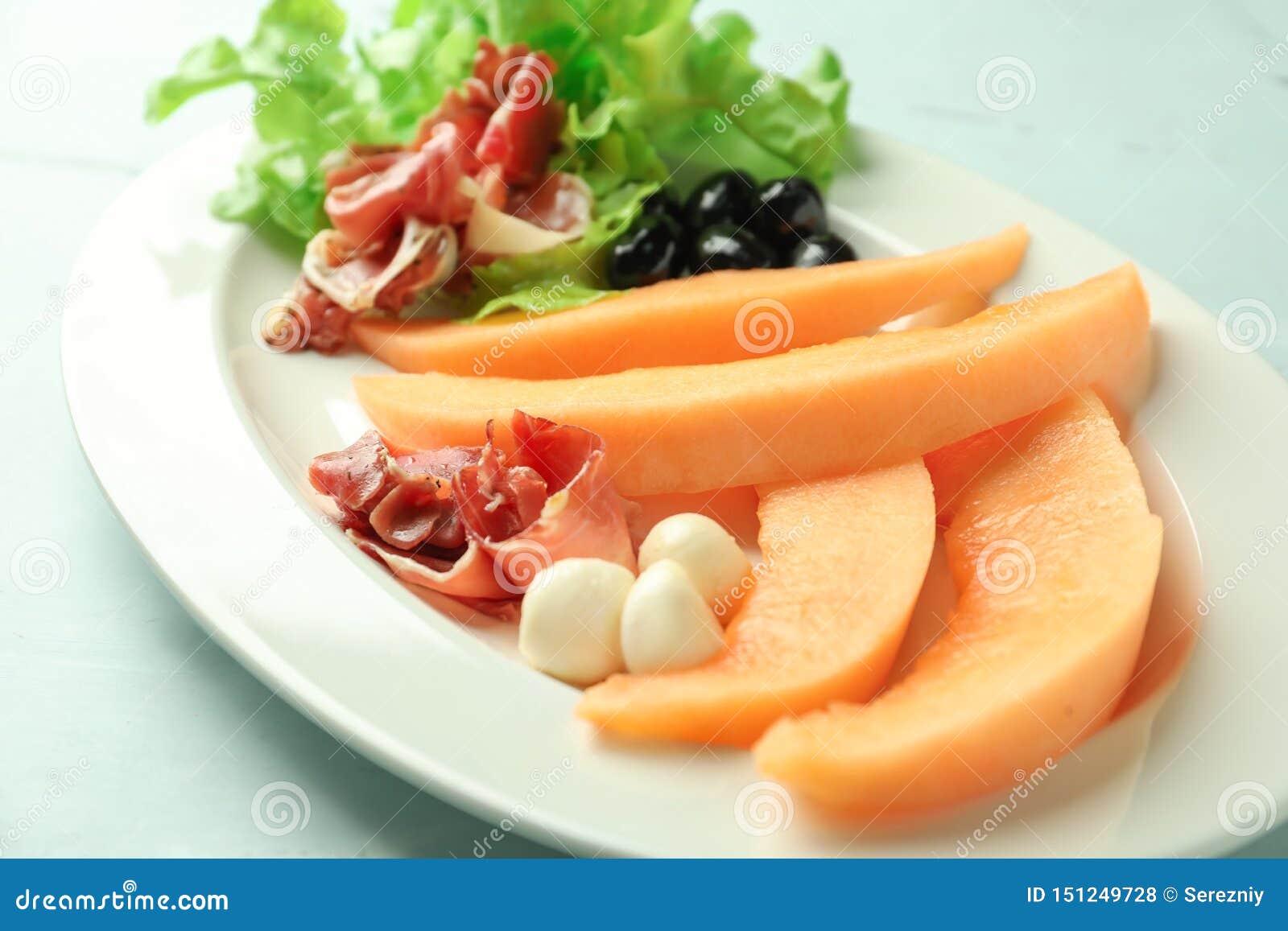 Delicious Melon with Prosciutto and Mozzarella on Plate, Closeup Stock