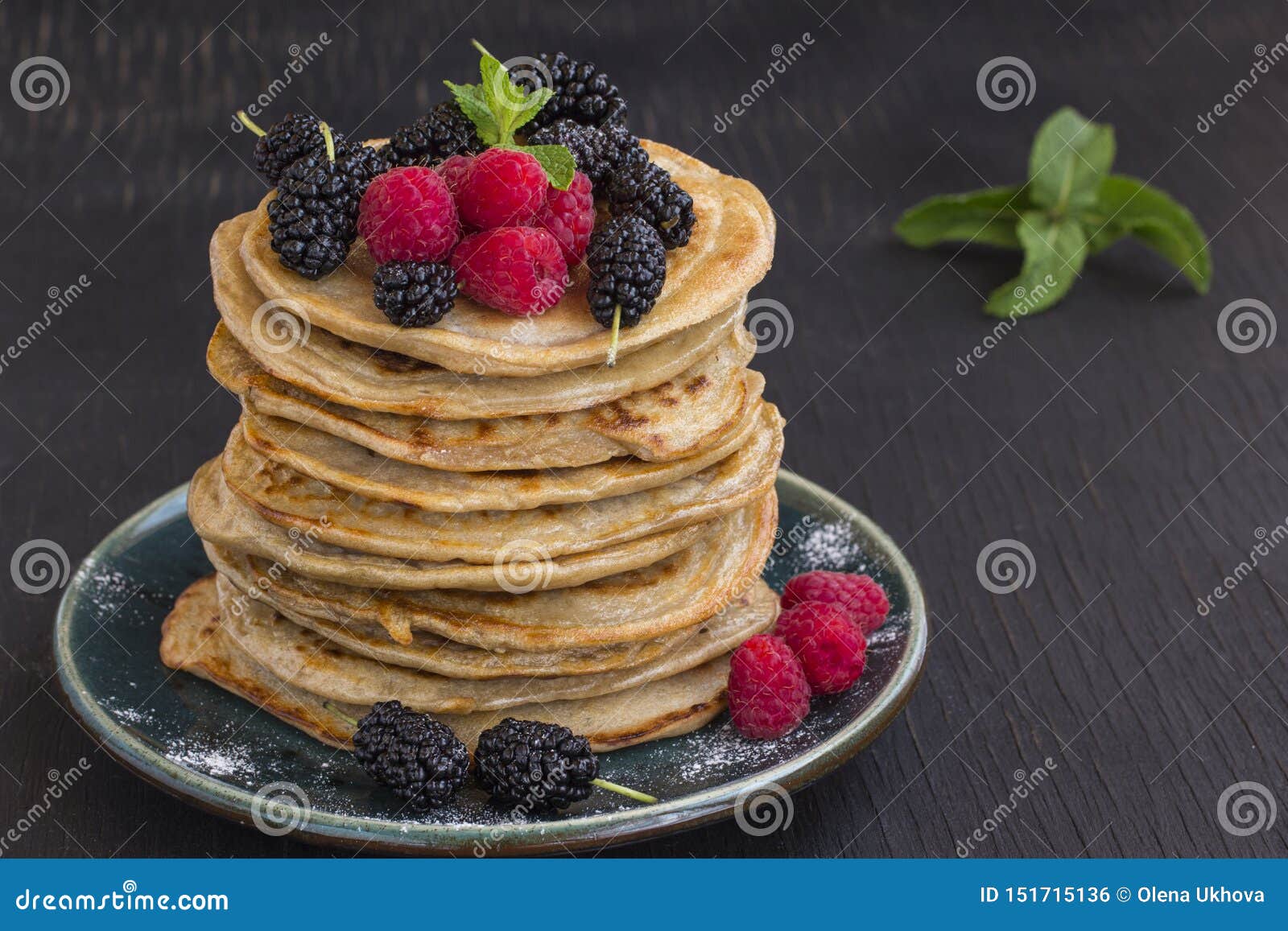 Delicious Pancake with Blackberries, Raspberries and Icing Sugar in Dish on Black Table Stock