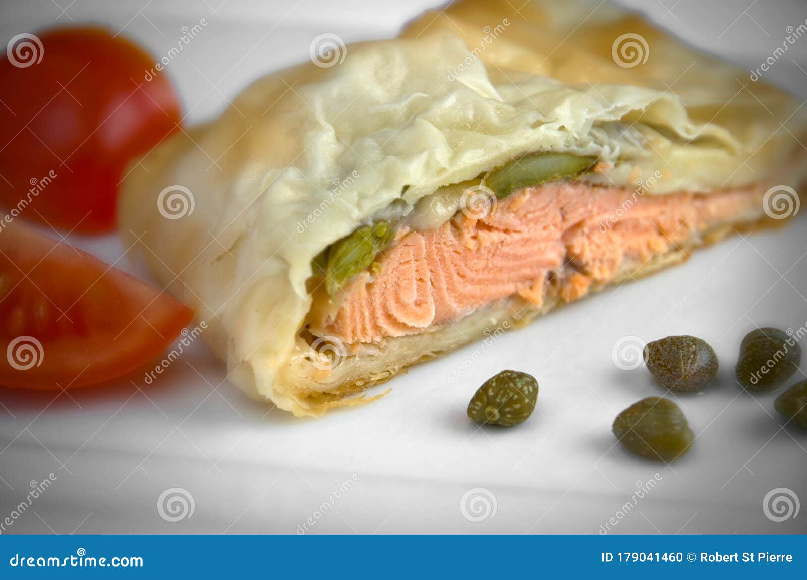 Delicious Phyllo Wrapped Salmon with Capers and Tomatoes on White Plate