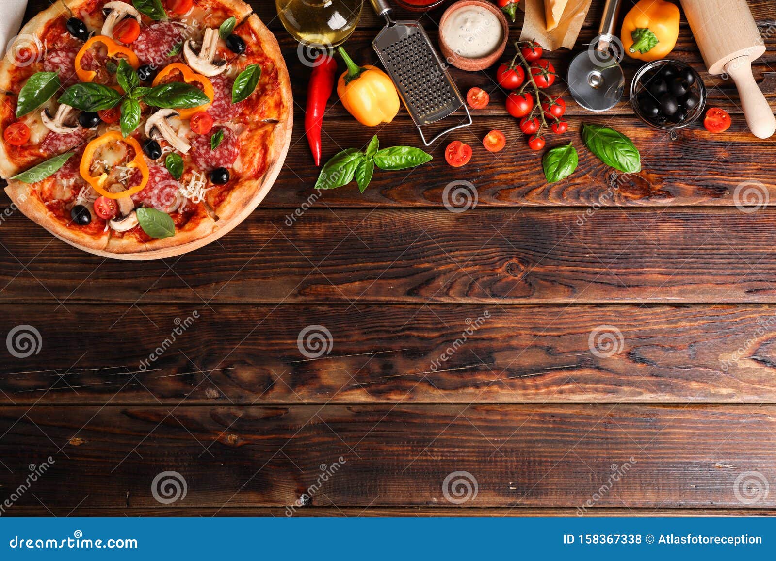delicious pizza and ingredients on wooden background