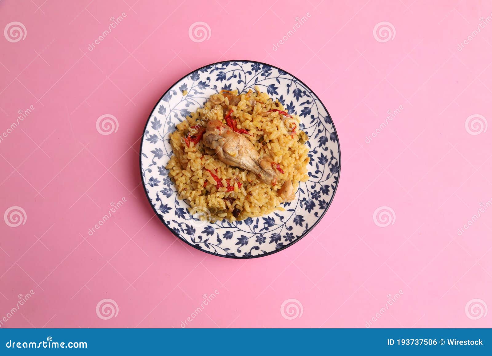 Delicious Rice Dish with Chicken Drumstick on the Plate on the Pink