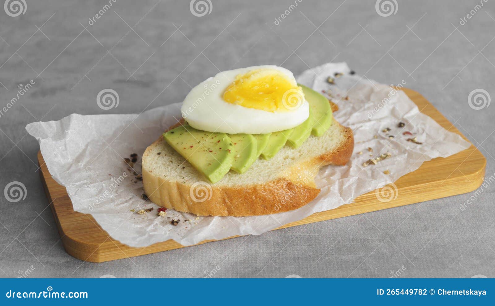 Delicious Sandwich with Boiled Egg and Pieces of Avocado on Gray Table