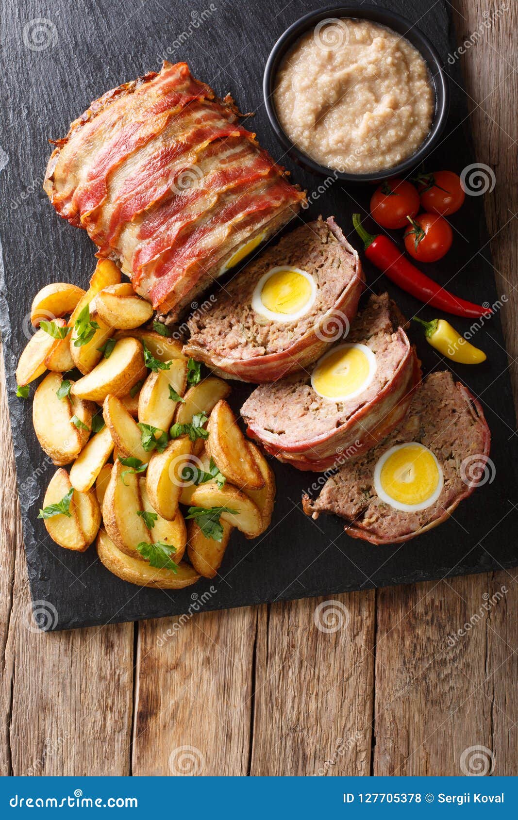 delicious sliced meat loaf wrapped in bacon with potato wedges a