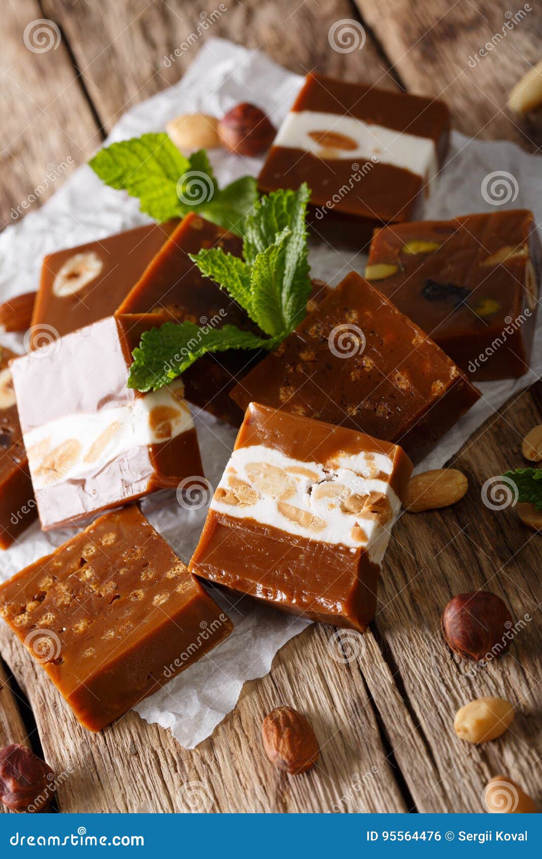 Delicious Soft Caramel Candy with Nuts Closeup on Parchment. Vertical Stock Photo Image of