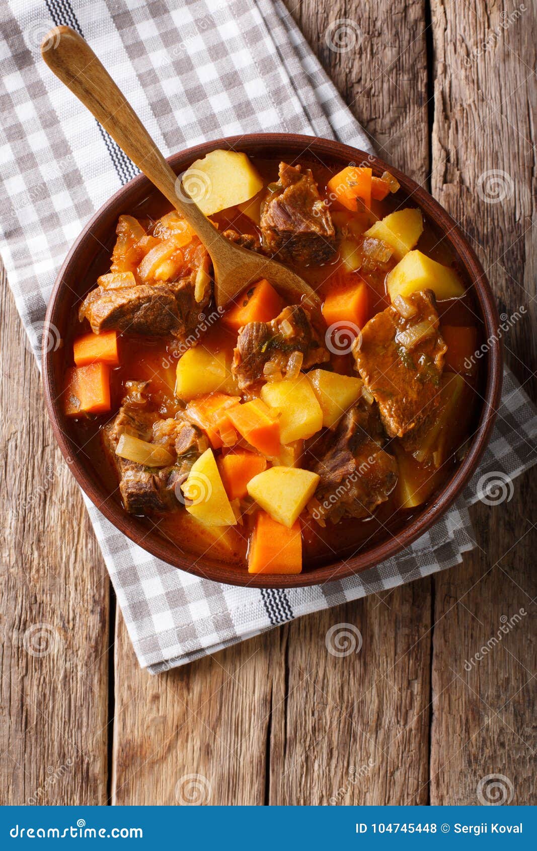 delicious stew estofado with beef and vegetables close-up. vertical top view