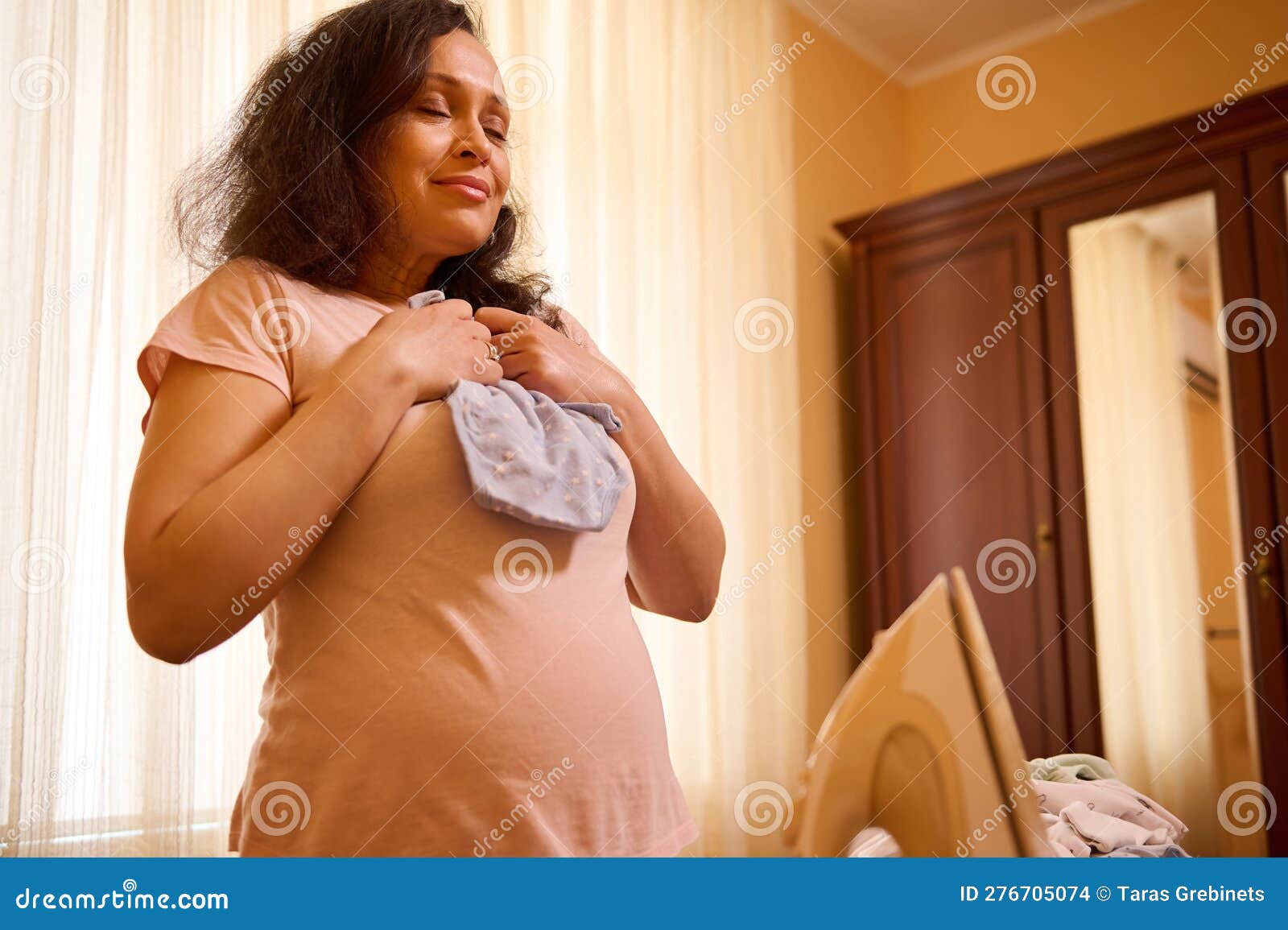 Delightful Pregnant Woman with Big Belly Holds an Ironed Bodysuit for Her  Future Newborn Baby. Stock Photo - Image of abdomen, cleanliness: 276705074