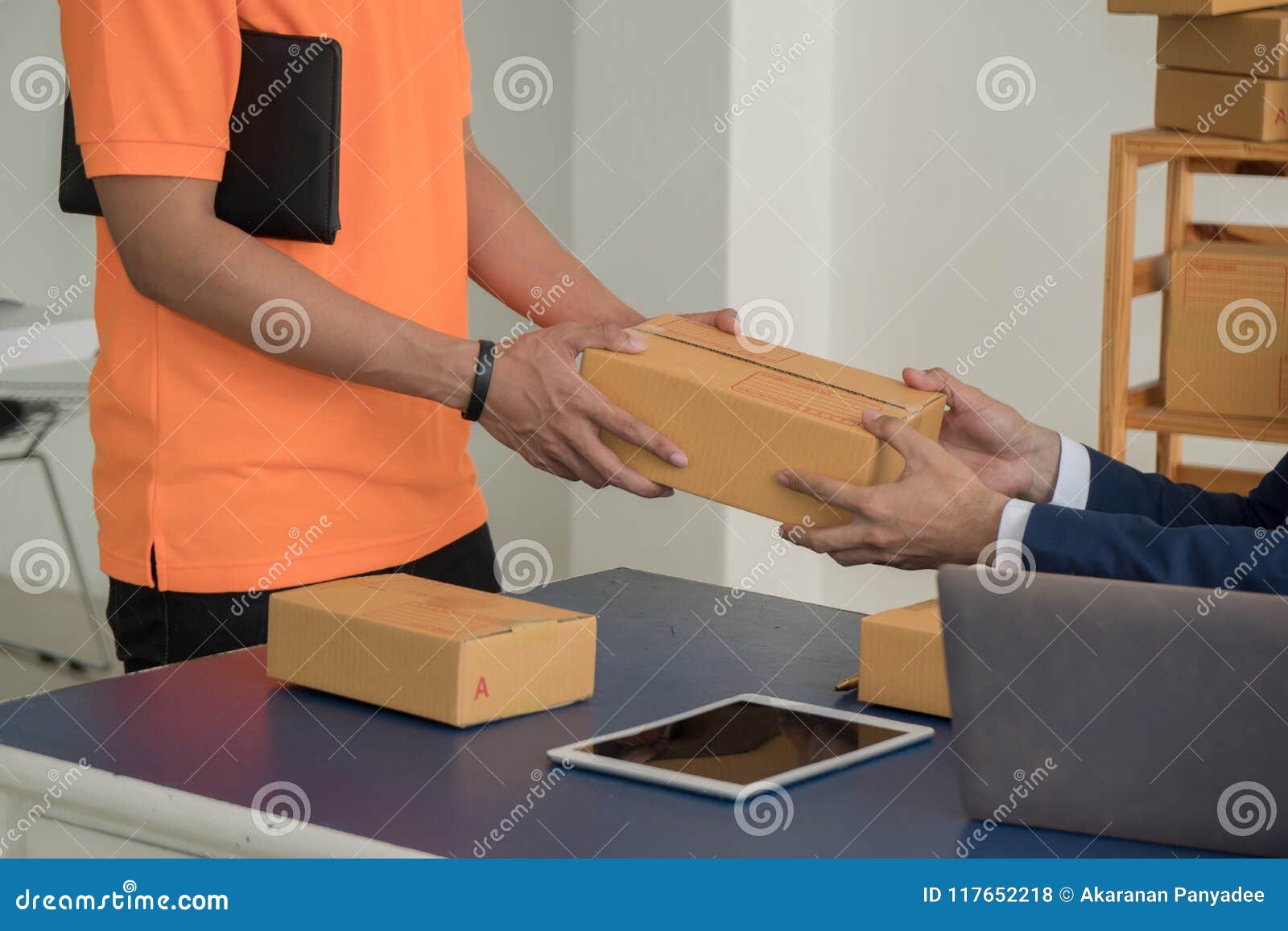 deliverer giving package box to business man.