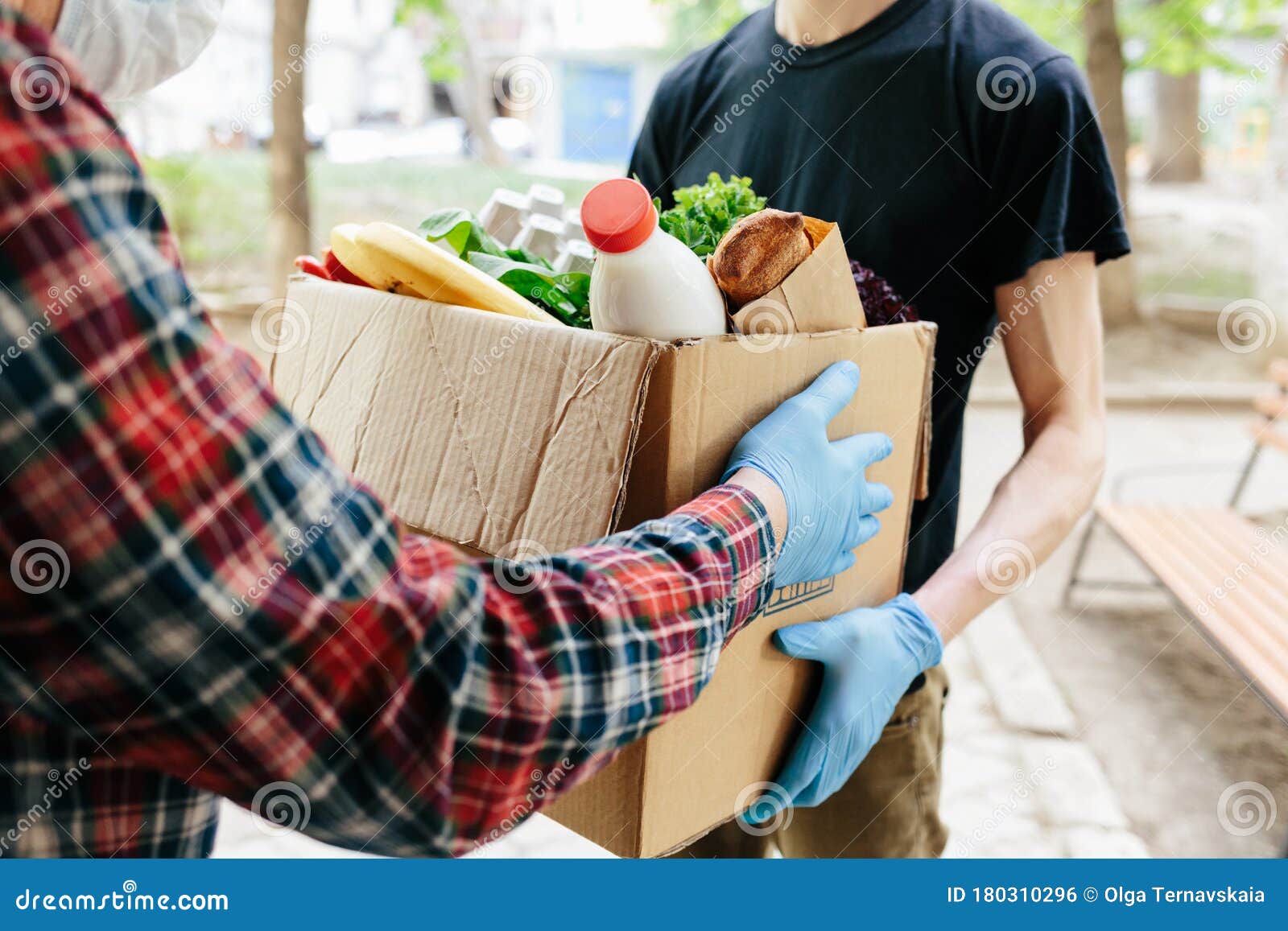 delivering food to senior citizens in quarantine during covid-19 coronavirus epidemic. courier in black shirt medical gloves