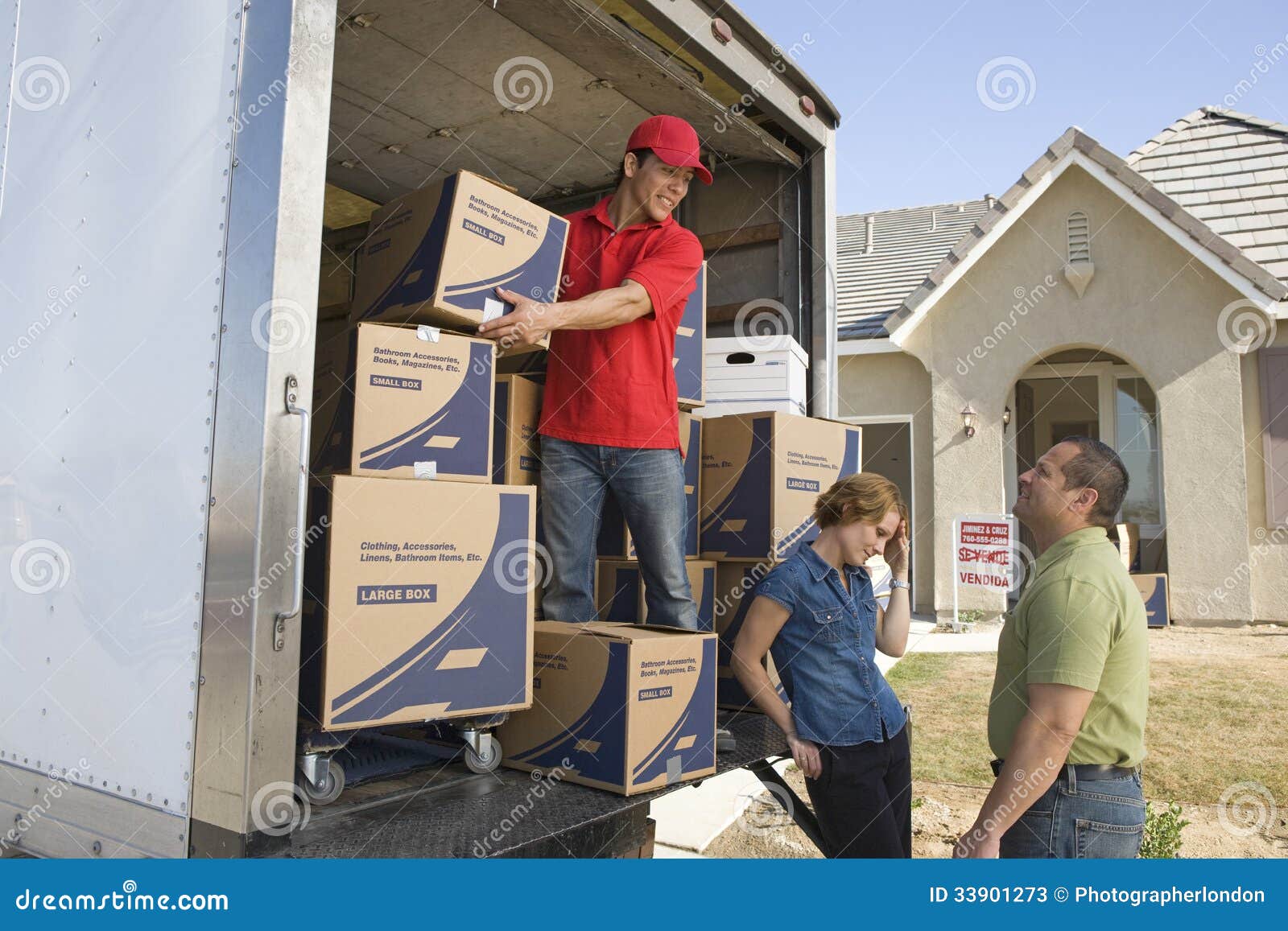 Delivery Man and Couple Unloading Moving Boxes from Truck Stock Image