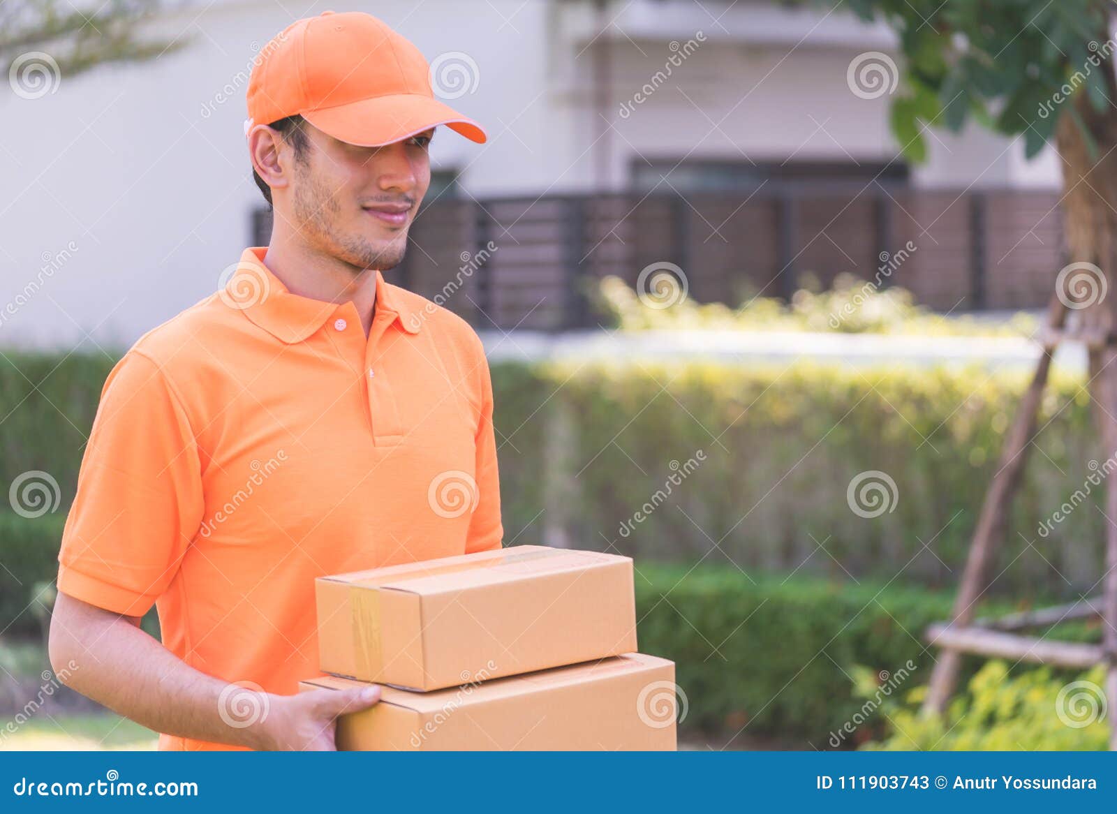 Delivery Man in Orange Bringing in the Package Stock Image Image of