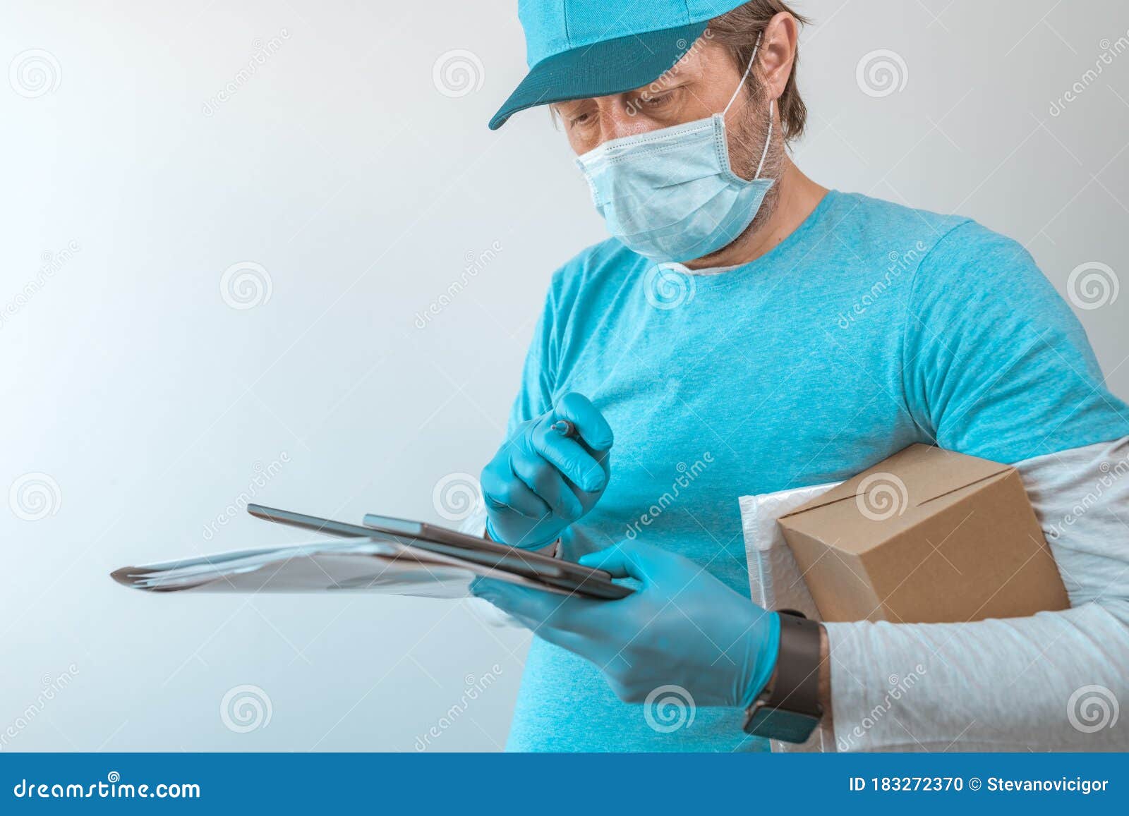 Delivery Man with Protective Clothing Using Digital Tablet Stock Photo