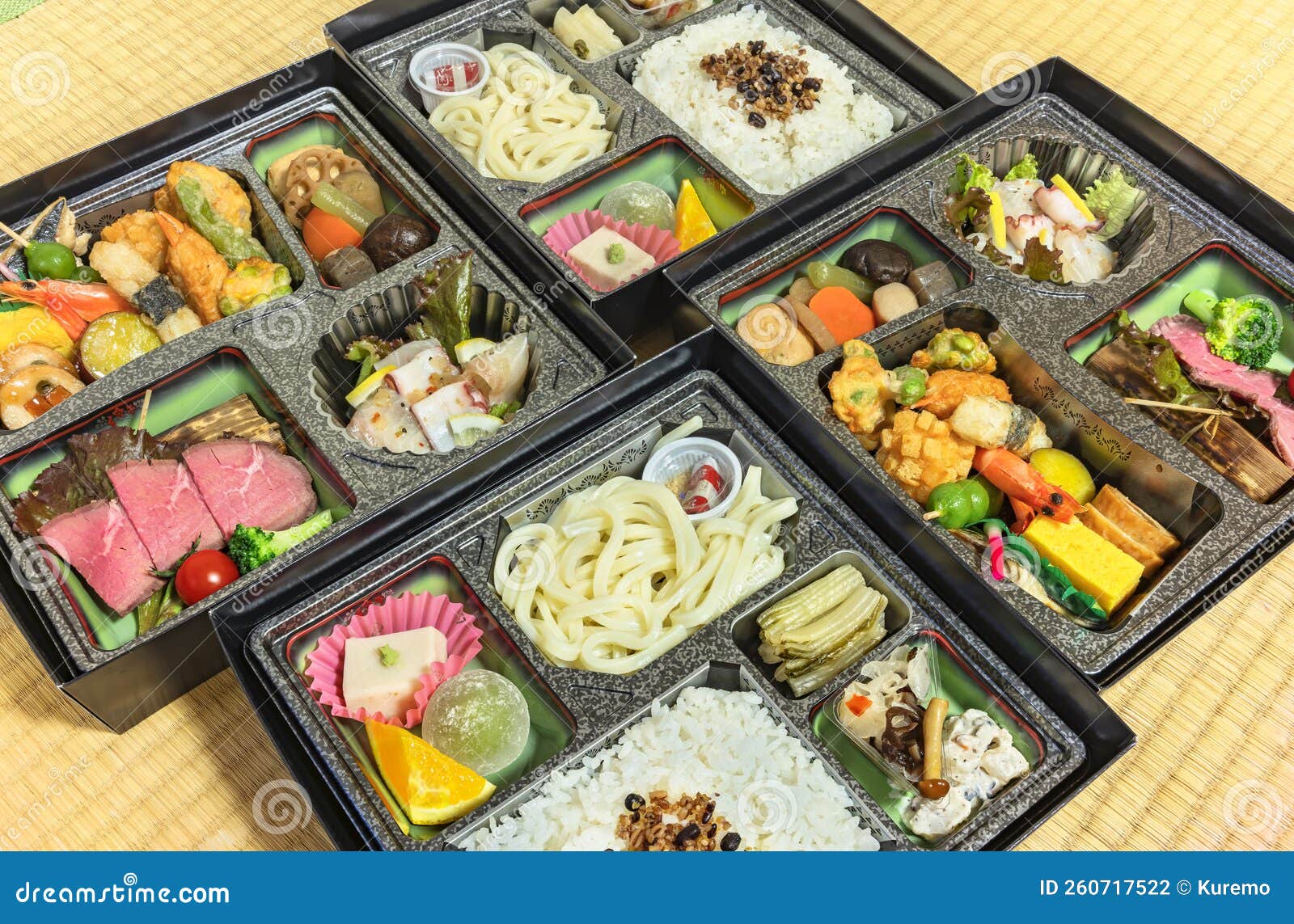 deluxe japanese makunouchi bento boxes with rice,udon noodles, tsukemono, nimono and sashimi on a tatami mat.