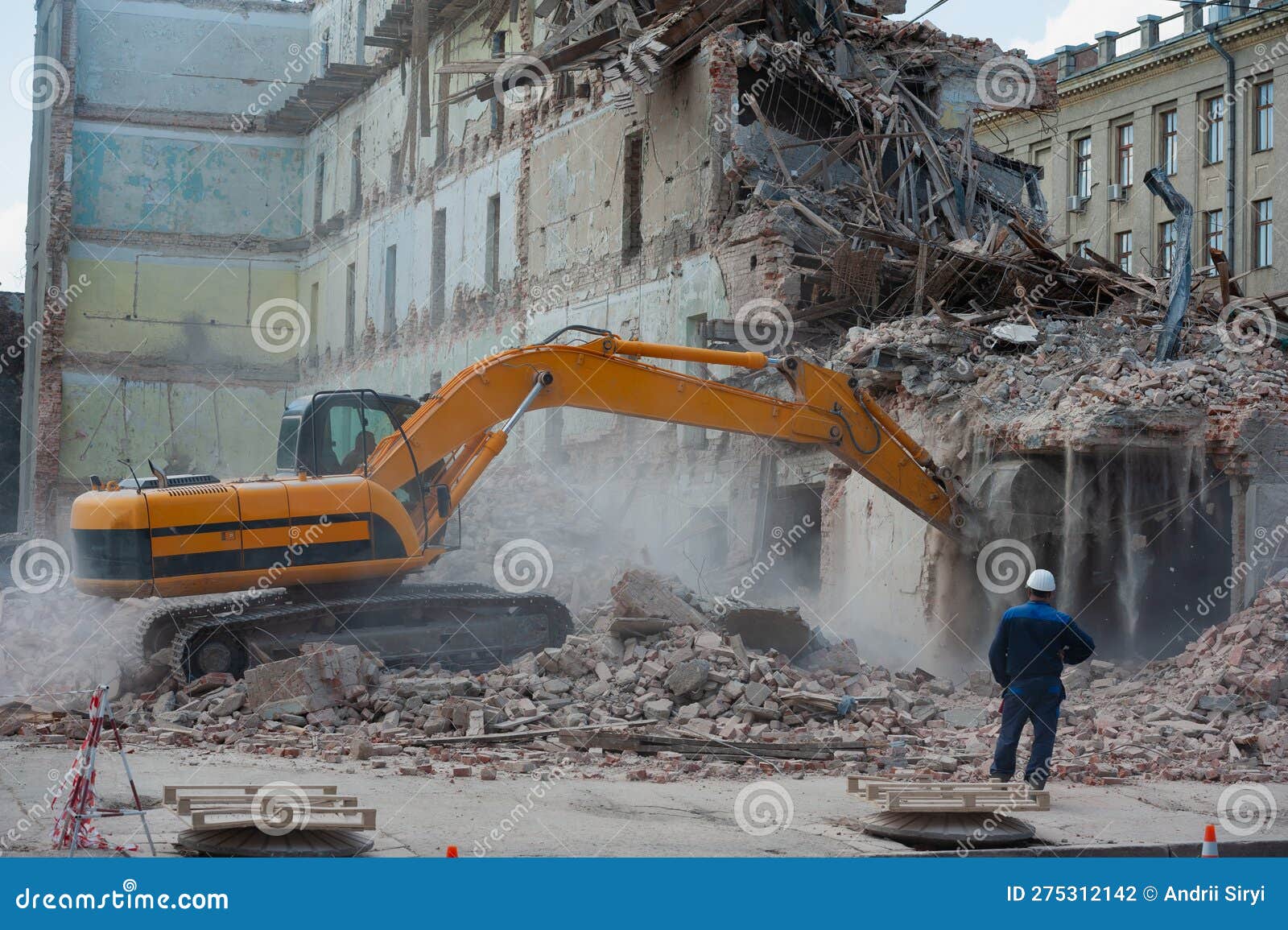 demolition of building. excavator breaks old house. freeing up space for construction of new building