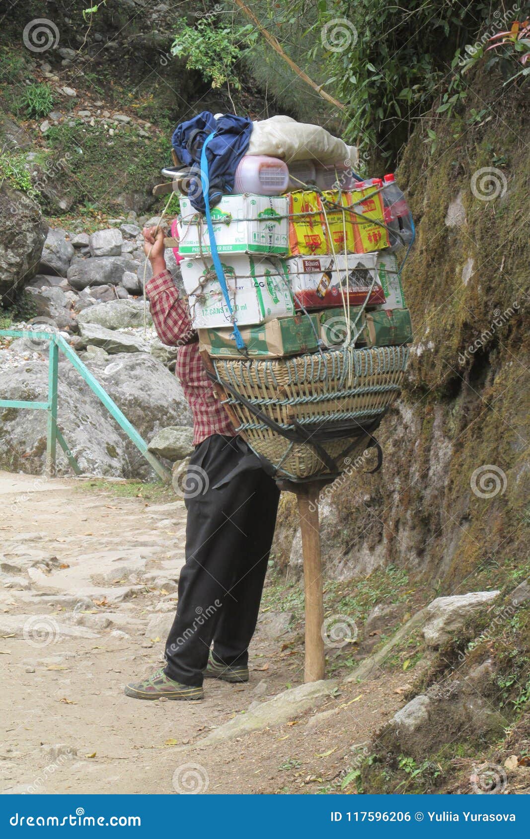 Den Sherpa portvakten bär korgen i Nepal den trekking banan. Den Sherpa portvaktskurkrollen laddade korgen i Nepal den trekking banan på Himalayasbergtreken