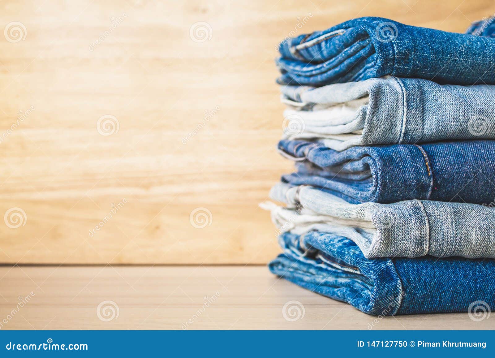 Denim Blue Jeans Stack On Wood Table Background Stock Photo - Image of ...