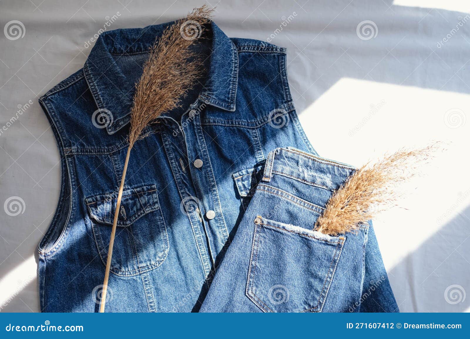 Denim Jacket and Dried Grass on White Background. Top View Stock Photo