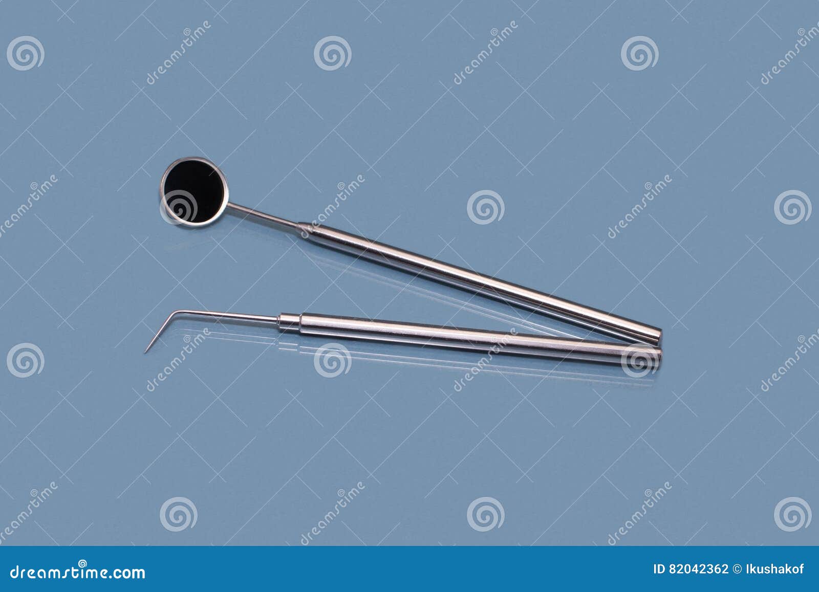 Dental Mirror and Dentist Probe. Image on Blue Background Stock Photo