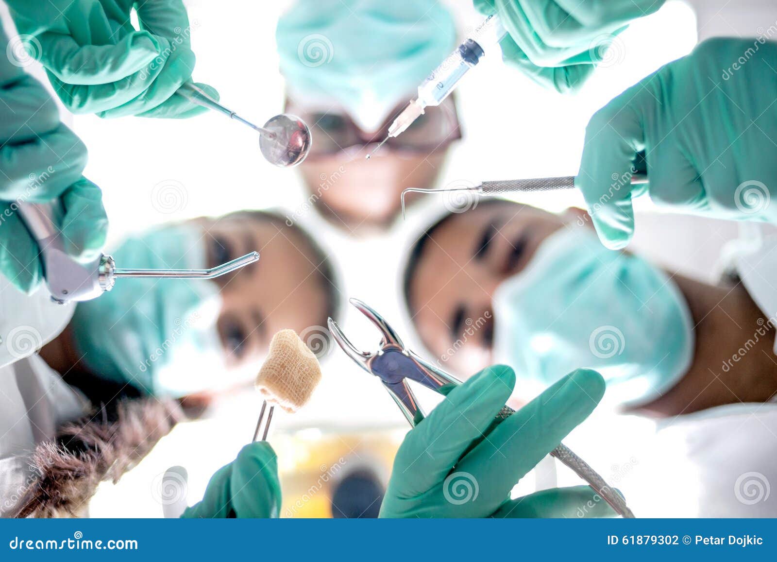 Dental Team Working with a Patient in Protective Work Wear Stock Photo
