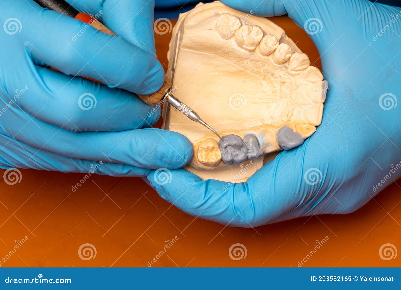Dental Technician Using a Brush with Ceramic Dental Implants in His
