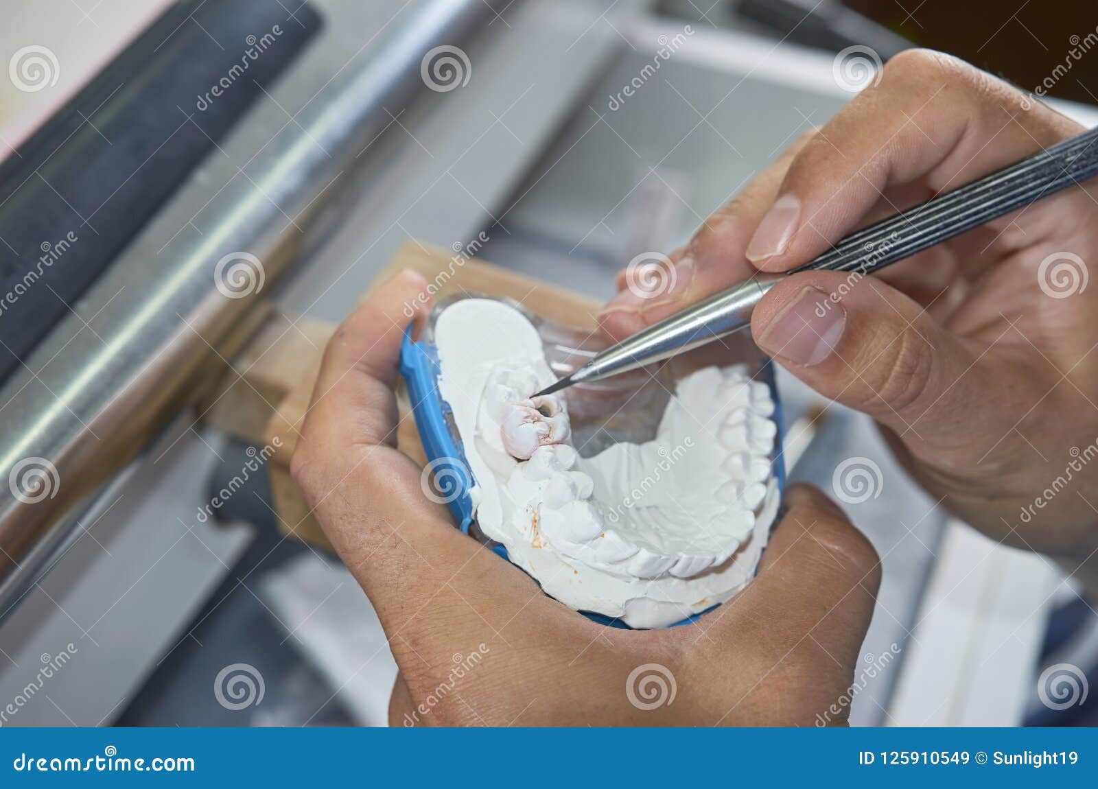 Dental Technician Working with Tools To Do Ceramic Dental Implants in