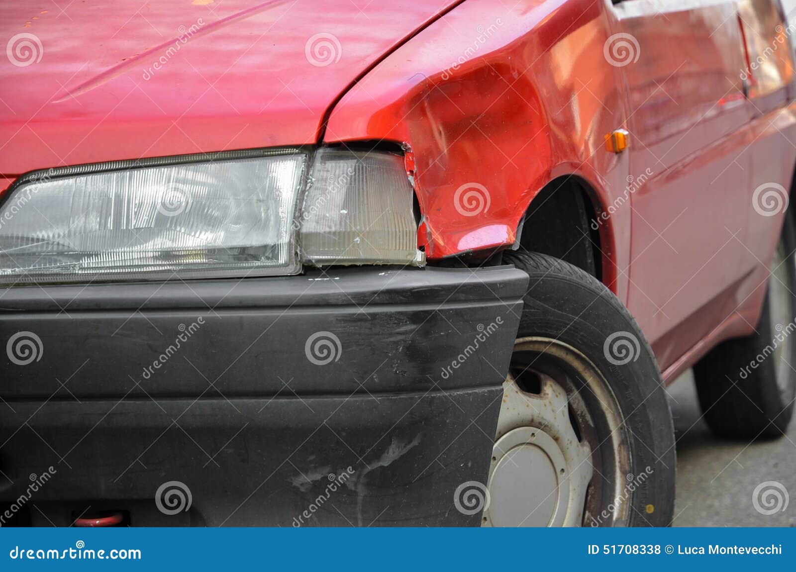 dented and scratched red car