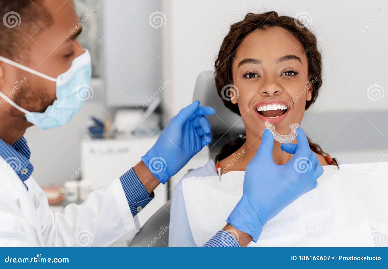 dentist applying invisible aligner on female patient teeth