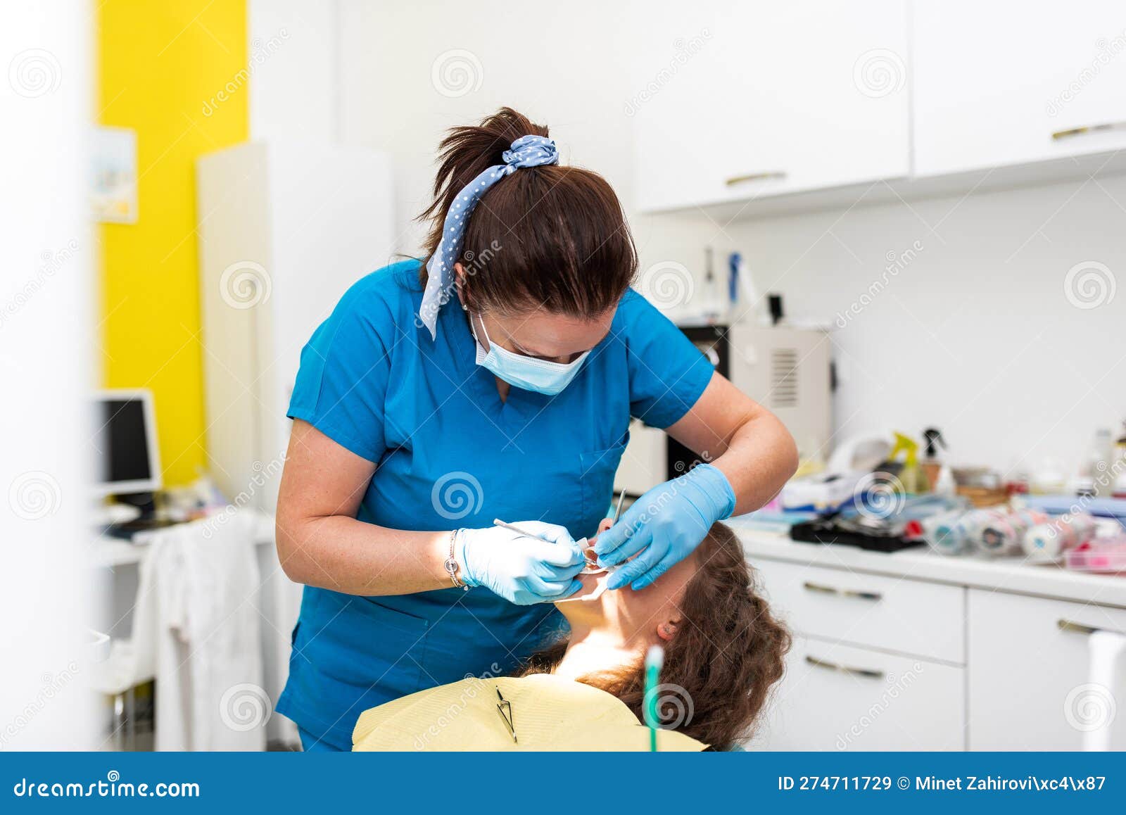 dentist appointment at a dental clinic, placing braces locks on the teeth and pulling the archwire to fix it